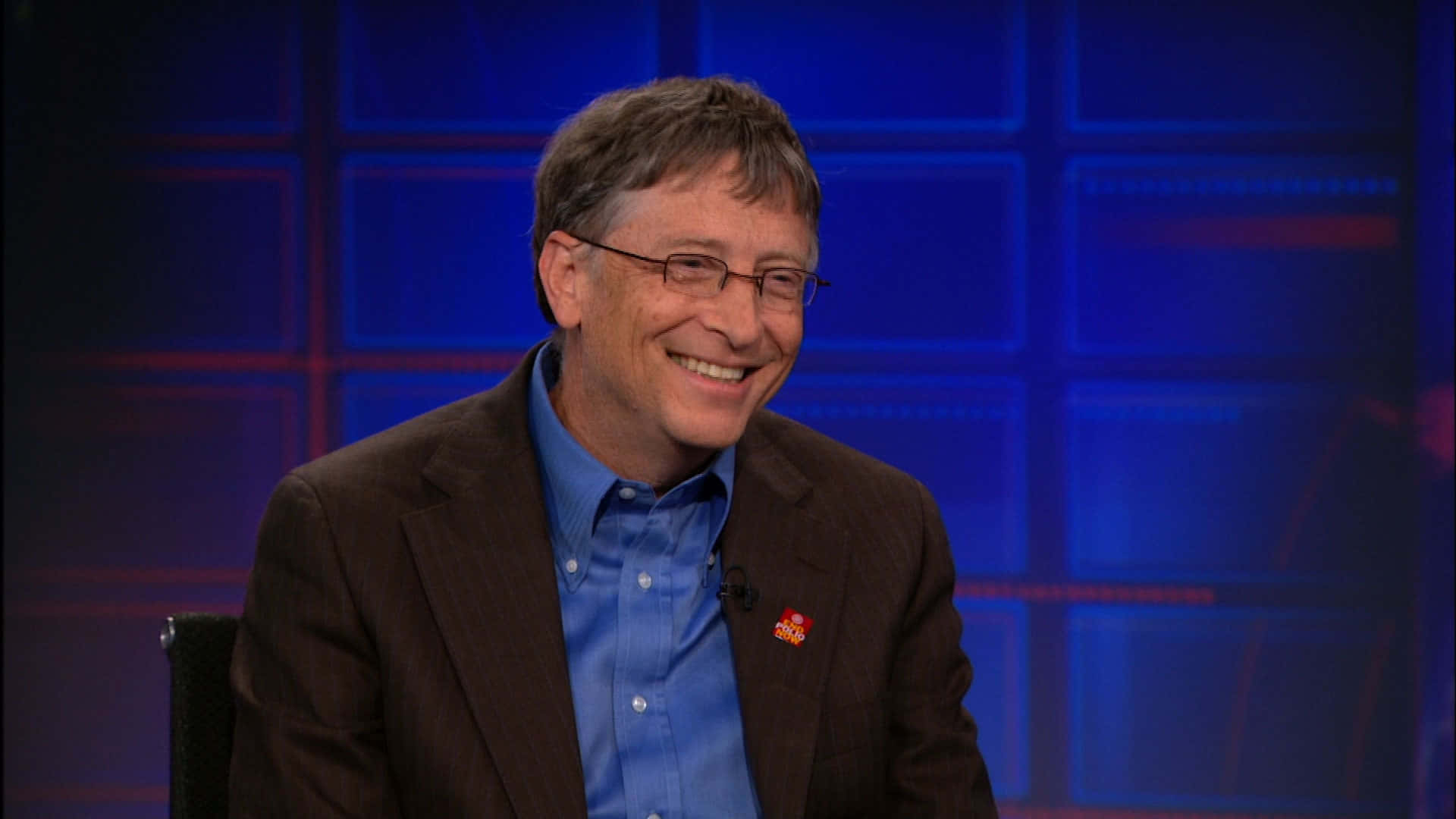 Bill Gates 桌布 壁紙 — 比爾·蓋茲在藍色網格背景的攝影棚內溫暖地微笑坐著。