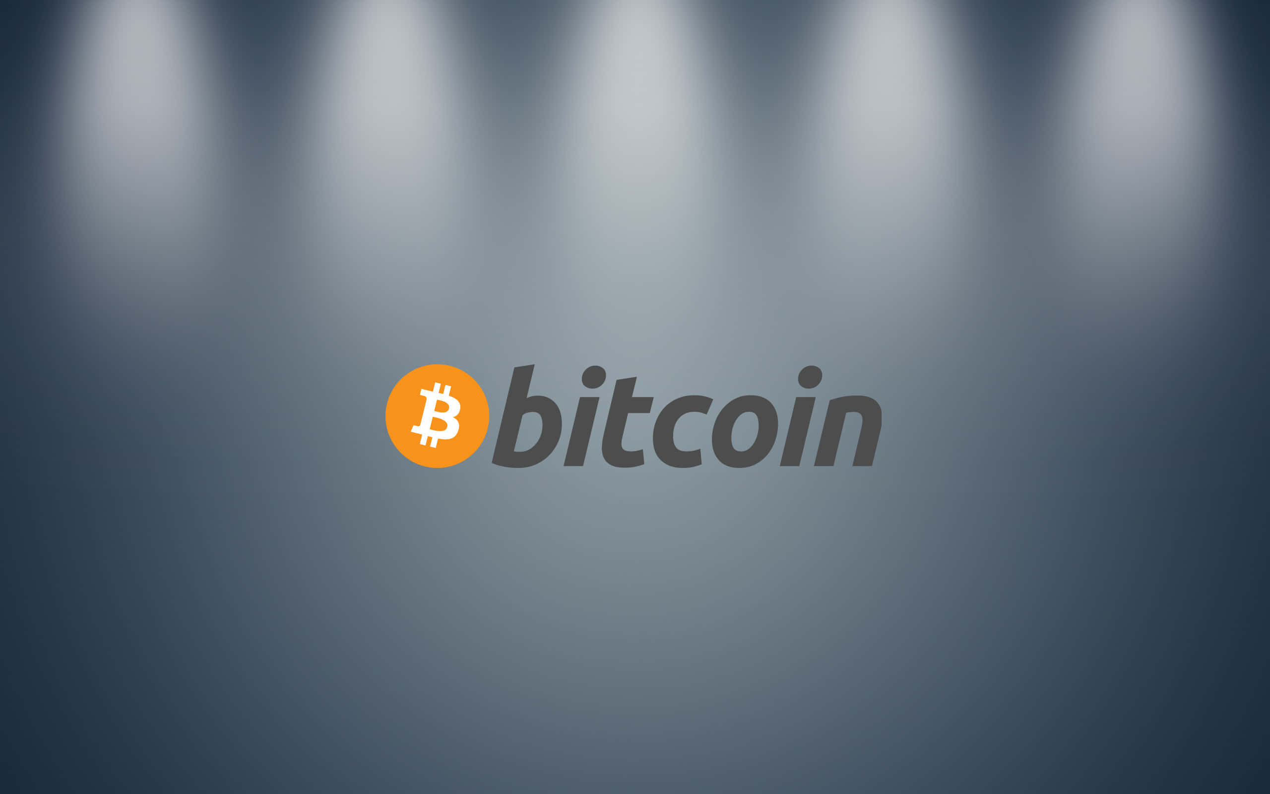 4K Bitcoin 桌布 壁紙 — 比特幣標誌在漸變灰色背景上被聚光燈照亮。
