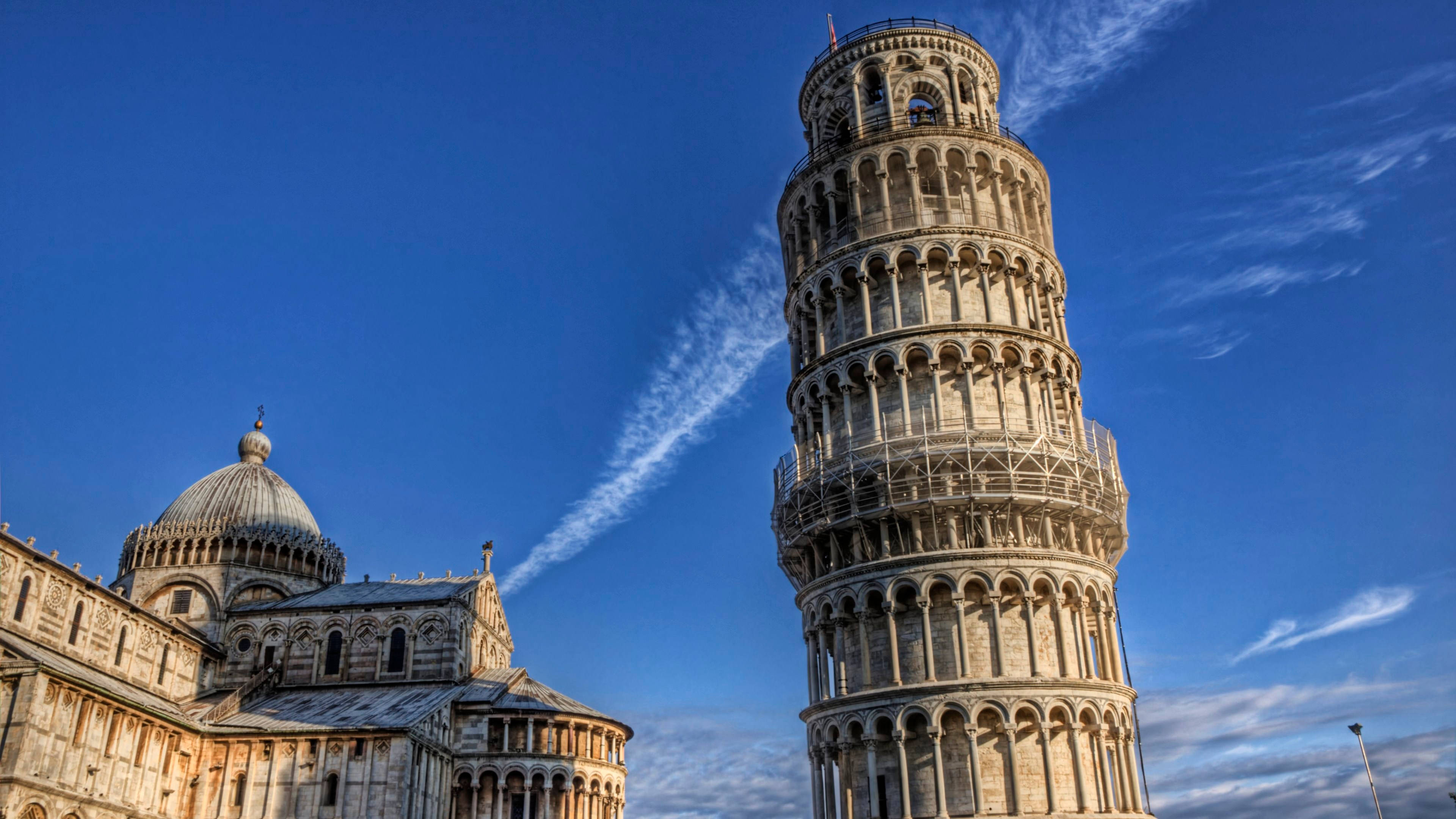 Tuscany 桌布 壁紙 — 比薩斜塔傾斜地矗立在充滿活力的藍天白雲下，旁邊是大教堂，沐浴在明亮的日光中。