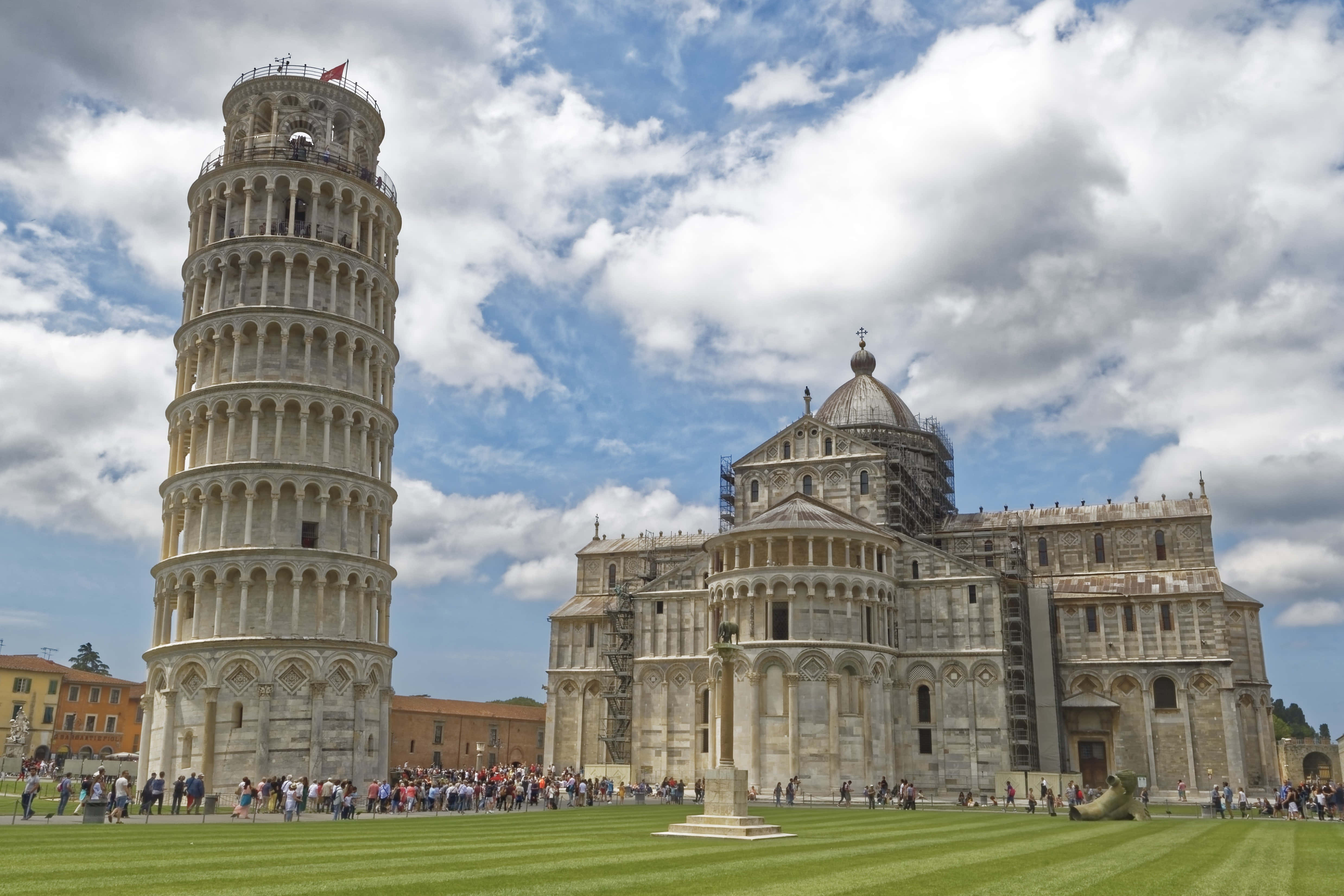 Pisa 桌布 壁紙 — 比薩斜塔傾斜地矗立在比薩大教堂旁邊，天空湛藍，白雲朵朵。