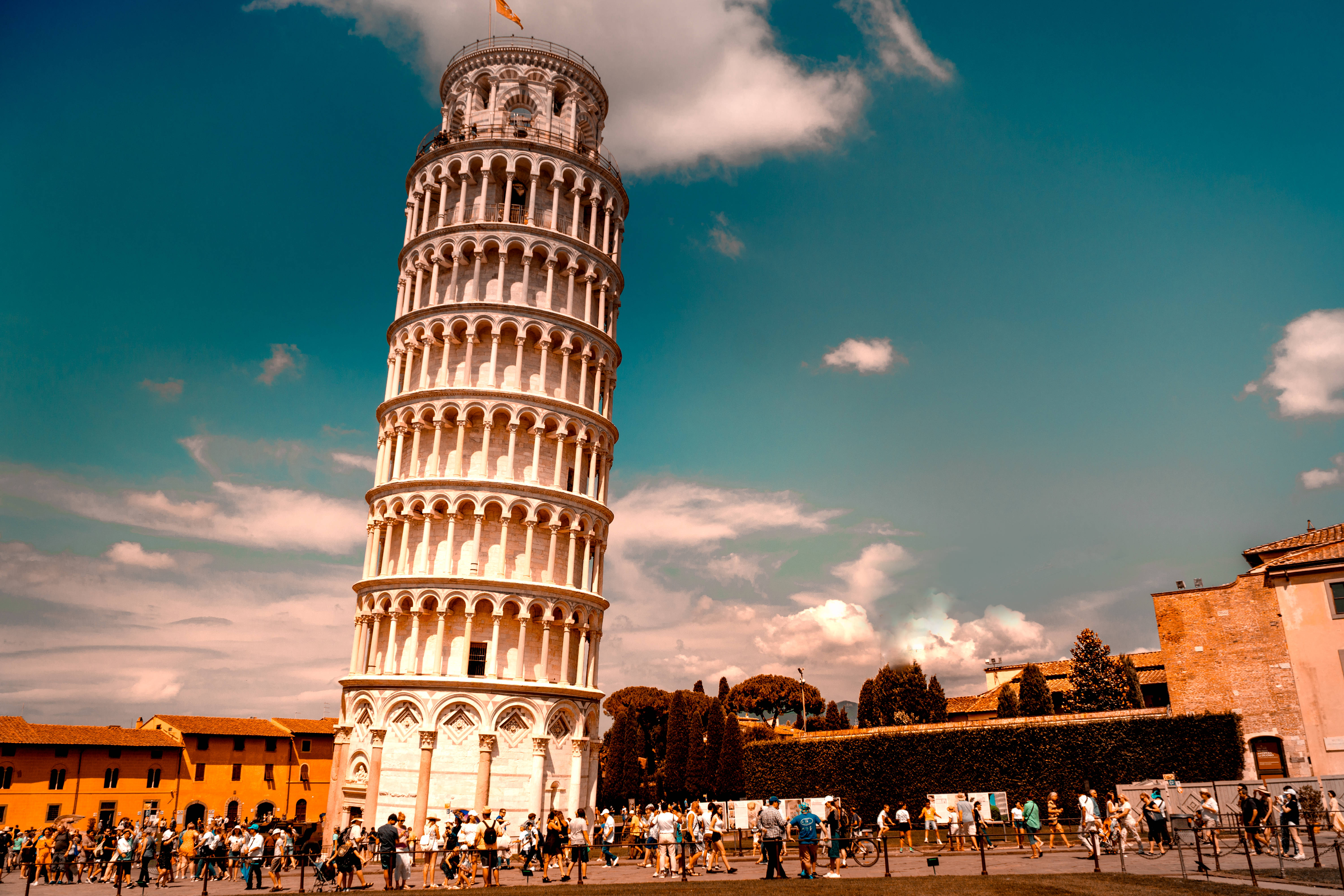 Tuscany 桌布 壁紙 — 比薩斜塔傾斜地矗立在藍天白雲下，遊客聚集在其底部。