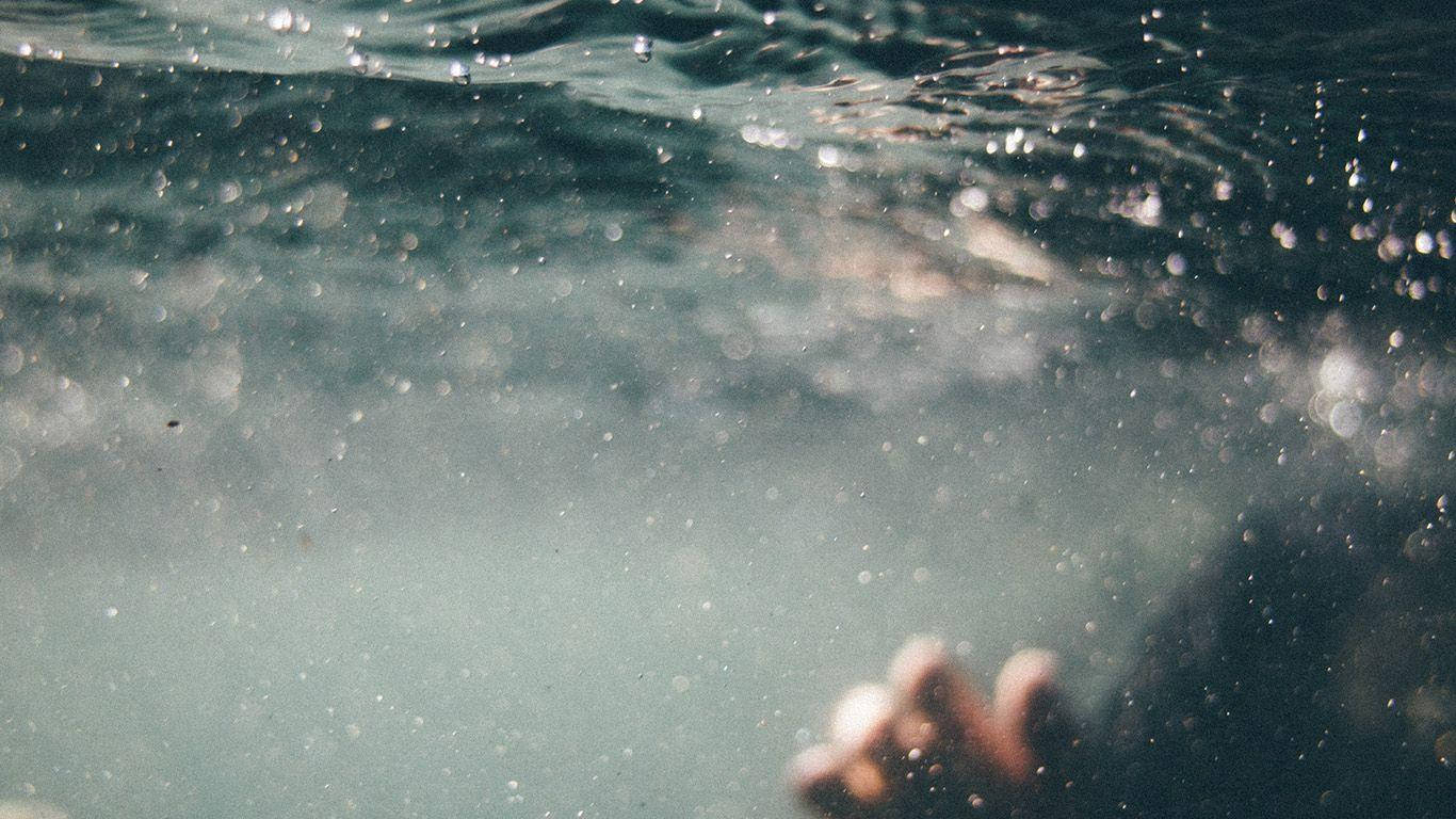 Swimming 桌布 壁紙 — 水下視角，一隻手穿過陽光照射、冒泡的水向上伸展，上方水面模糊。