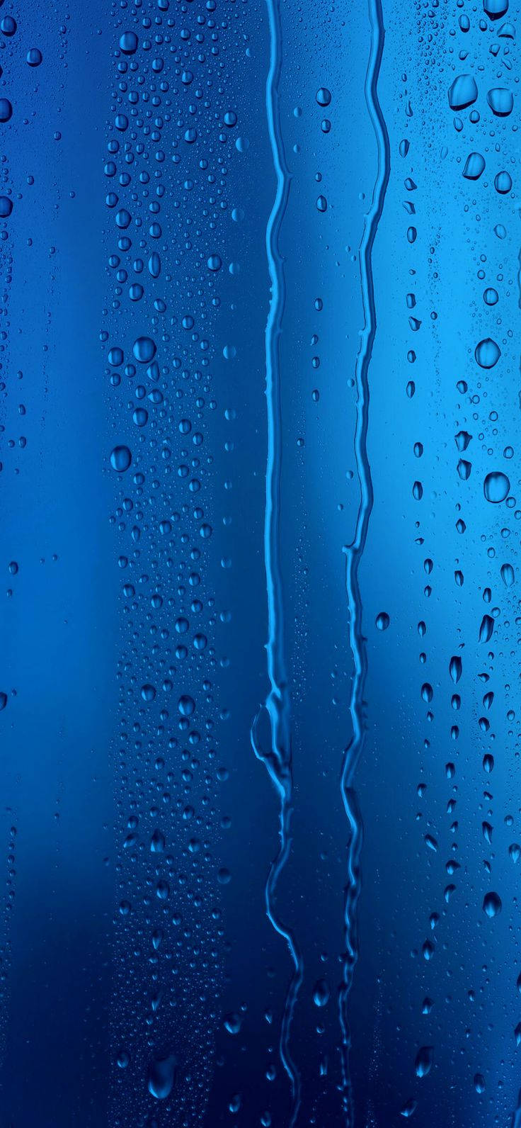 水滴在藍色玻璃表面滑落。 — iPhone 14 壁紙