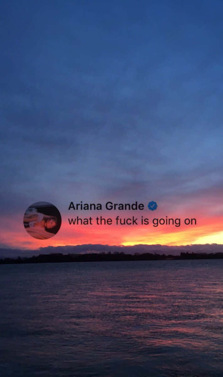 Ariana Grande Aesthetic 桌布 壁紙 — 水面上的戲劇性日落，火橙色和粉紅色的雲彩映襯著深藍色的天空，並帶有社交媒體疊加層。