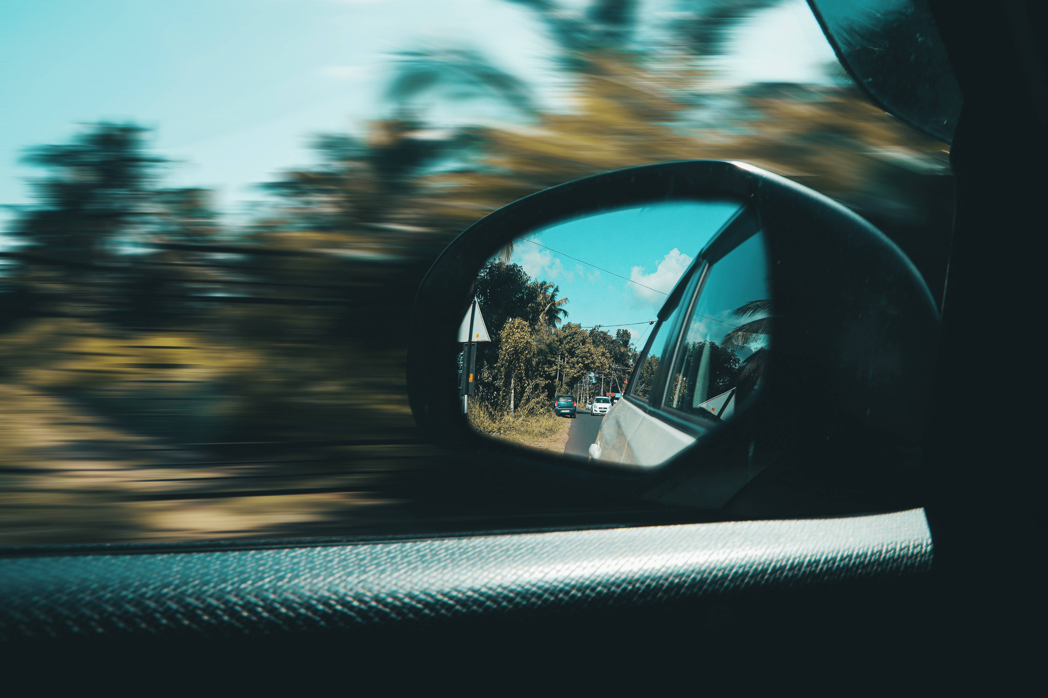 Moving 桌布 壁紙 — 汽車側鏡反射出晴朗藍天和棕櫚樹成蔭的道路，動態模糊劃過窗外掠過的風景。