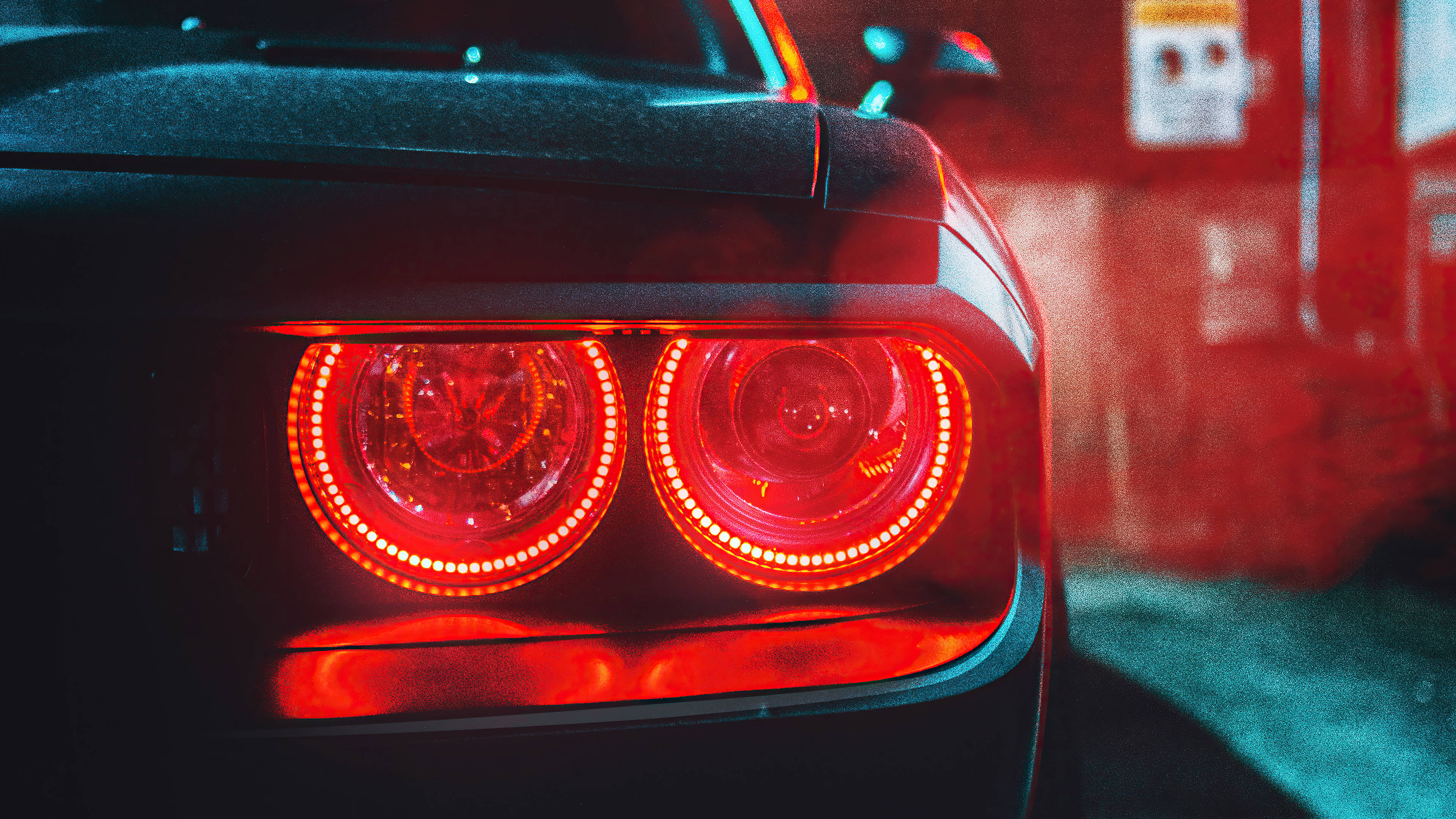 Cool Car 桌布 壁紙 — 汽車紅色發光尾燈在昏暗車庫中帶有霓虹藍和紅色環境照明的特寫。