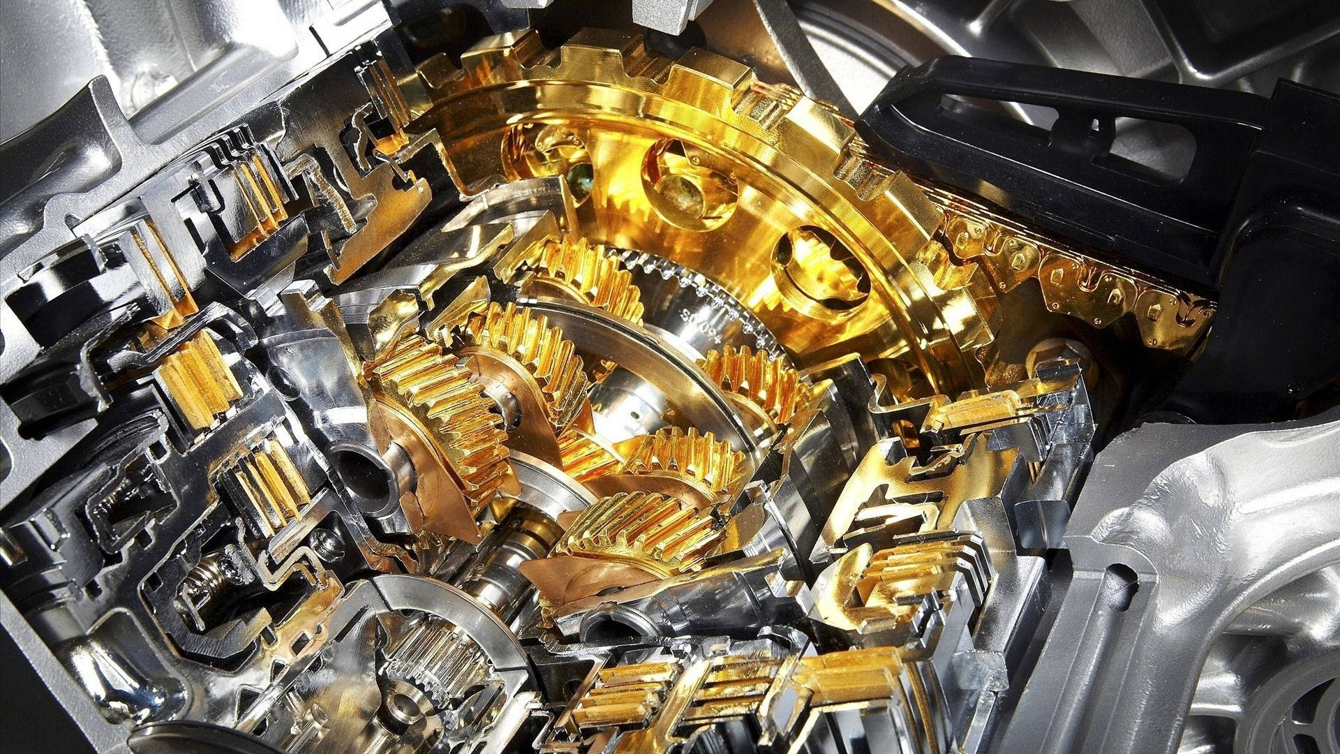 金色動態 桌布 壁紙 — 汽車變速箱內部複雜的金色和銀色齒輪及機械零件的特寫。