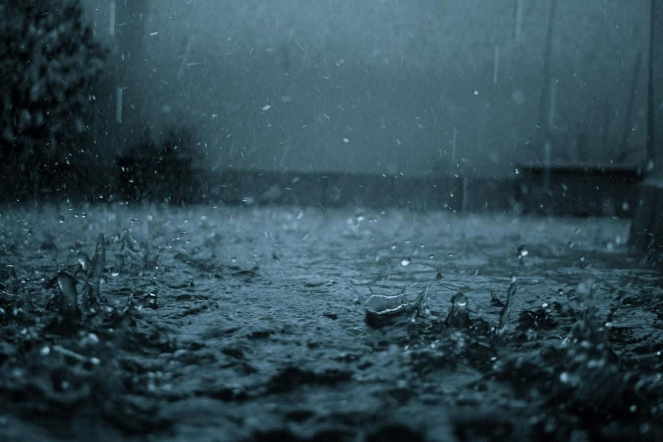 Rain Desktop 桌布 壁紙 — 沉重的雨滴在陰沉的灰色天空下戲劇性地濺在潮濕的路面上。