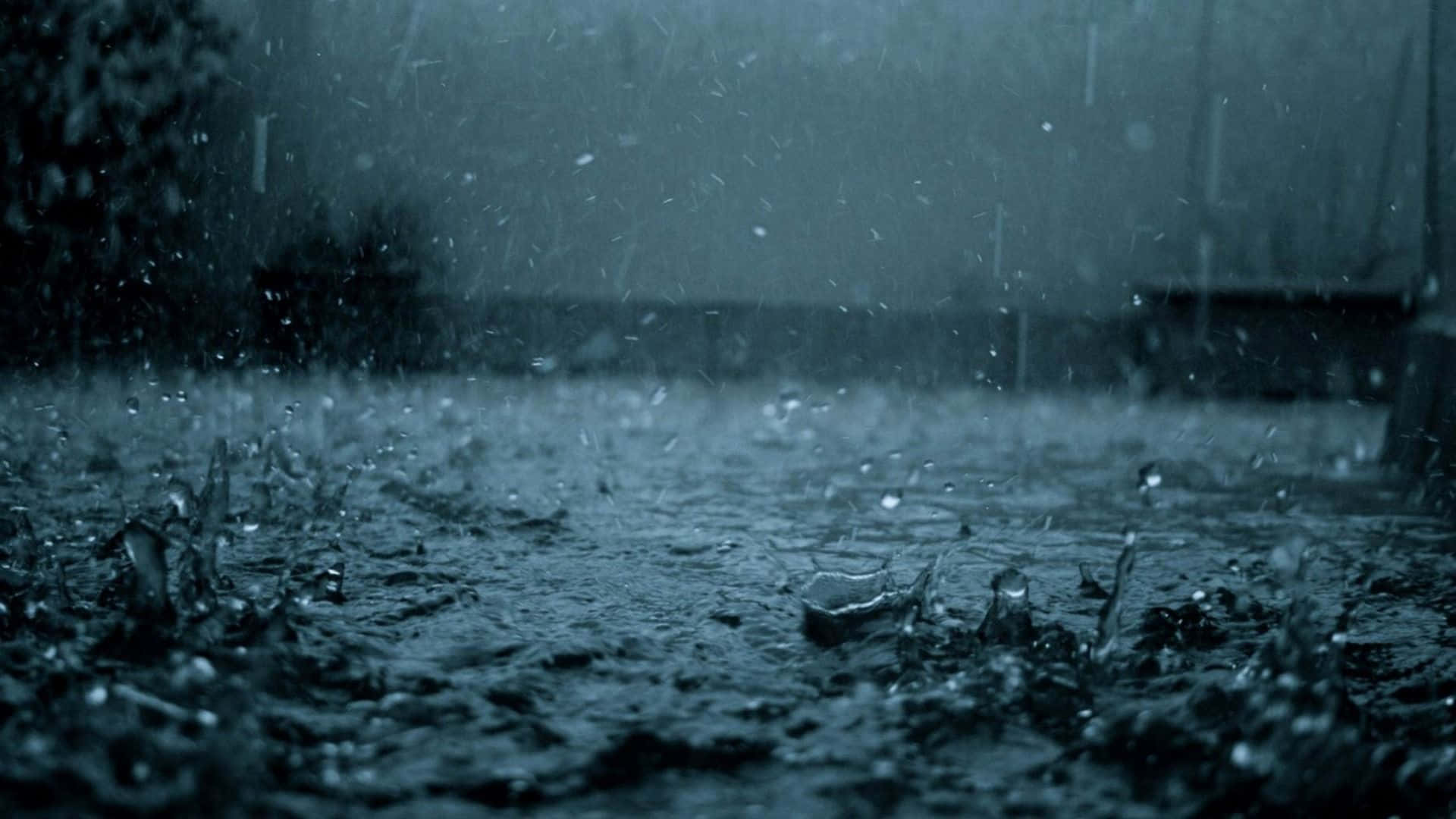 下雨 桌布 壁紙 — 沉重的雨滴撞擊濕漉漉的路面，在昏暗的藍灰色光線下形成尖銳的水花。