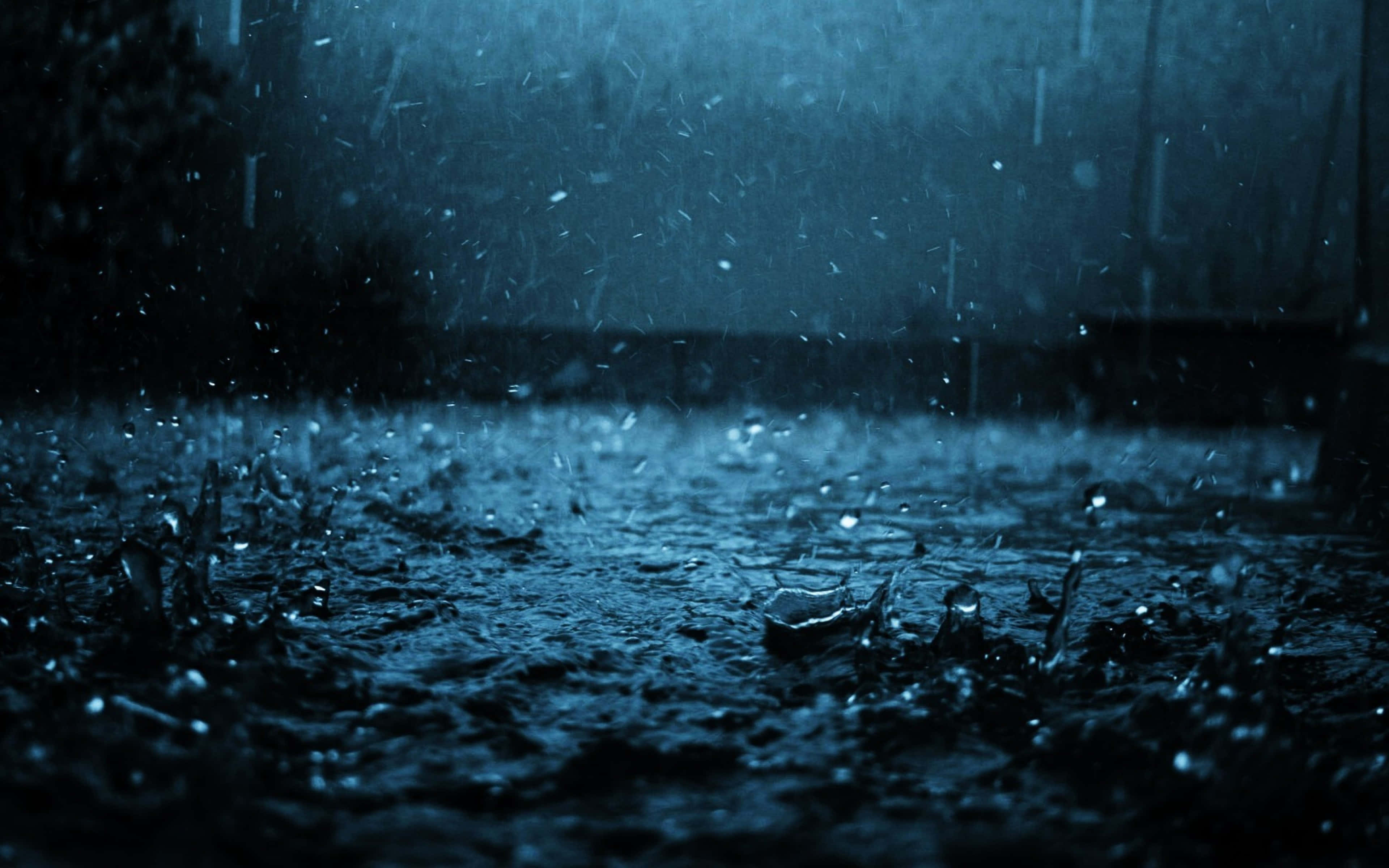 下雨 桌布 壁紙 — 沉重的雨點在陰鬱的藍色暮色天空下，戲劇性地濺落在黑暗潮濕的路面上。