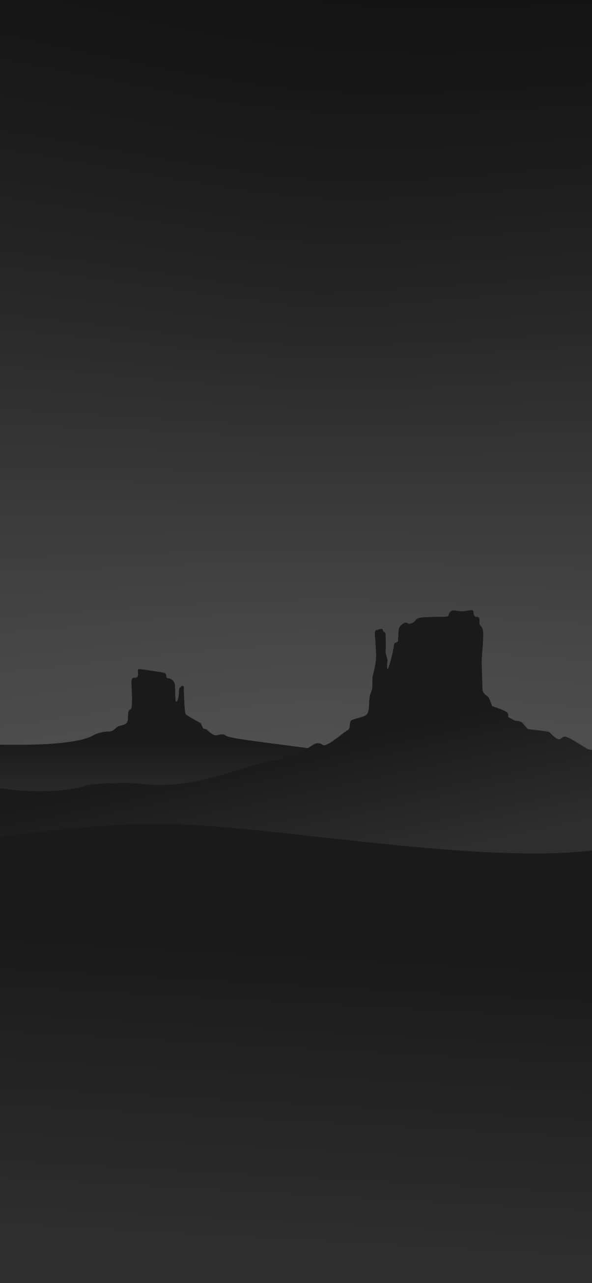 Minimalist Gray 桌布 壁紙 — 沙漠孤峰的剪影在漸變暮色天空下升起，呈現極簡單色調景觀。