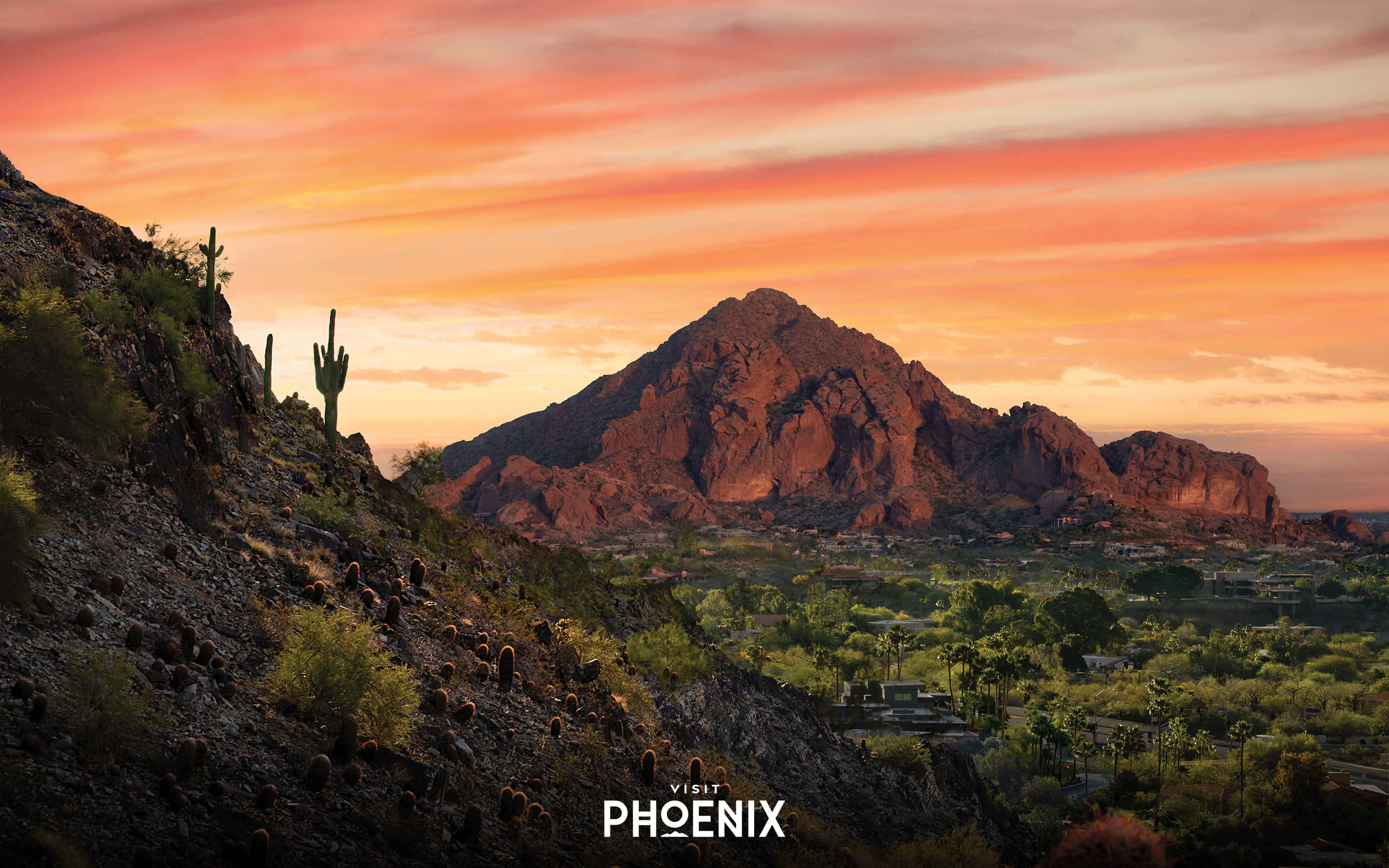 Phoenix Arizona 桌布 壁紙 — 沙漠日落將紅色岩石山脈和仙人掌沐浴在溫暖的橙色光芒中，照耀著山谷小鎮。