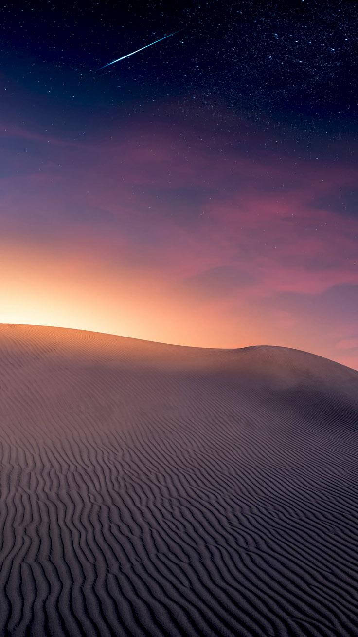 Desert 桌布 壁紙 — 沙漠沙丘在繁星點點的暮色天空下，一顆流星劃過紫色和橙色的天空。
