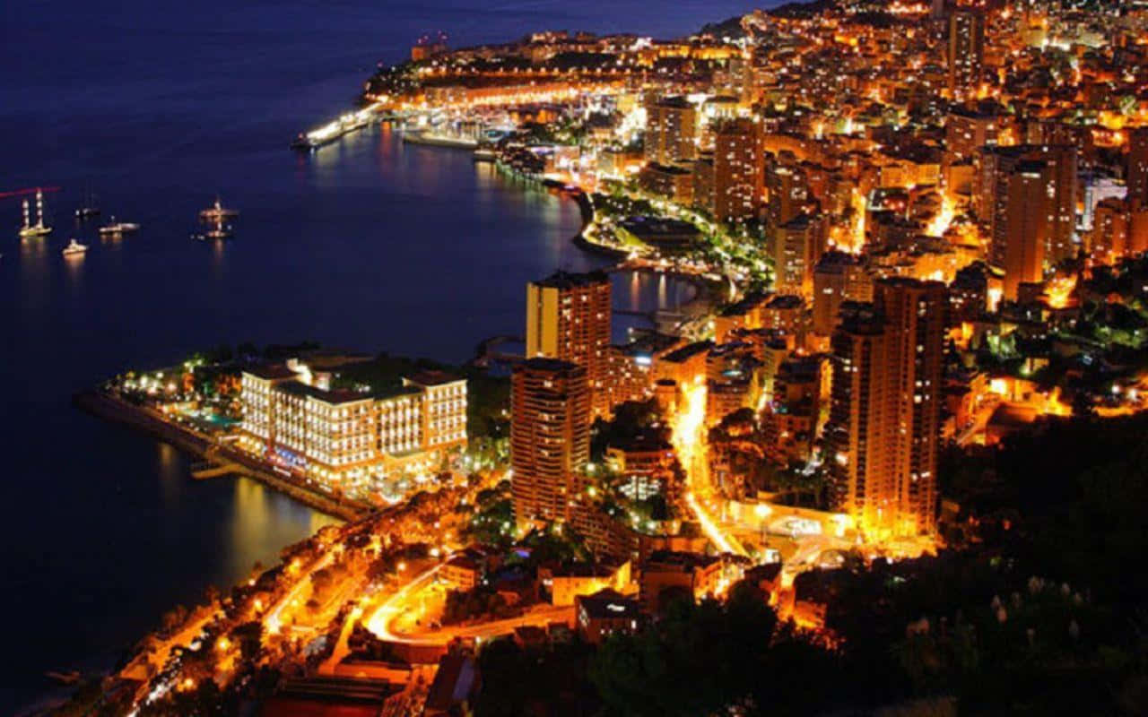 Europe 桌布 壁紙 — 沿海城市夜景鳥瞰圖，海濱和山坡上閃爍著溫暖的燈光。