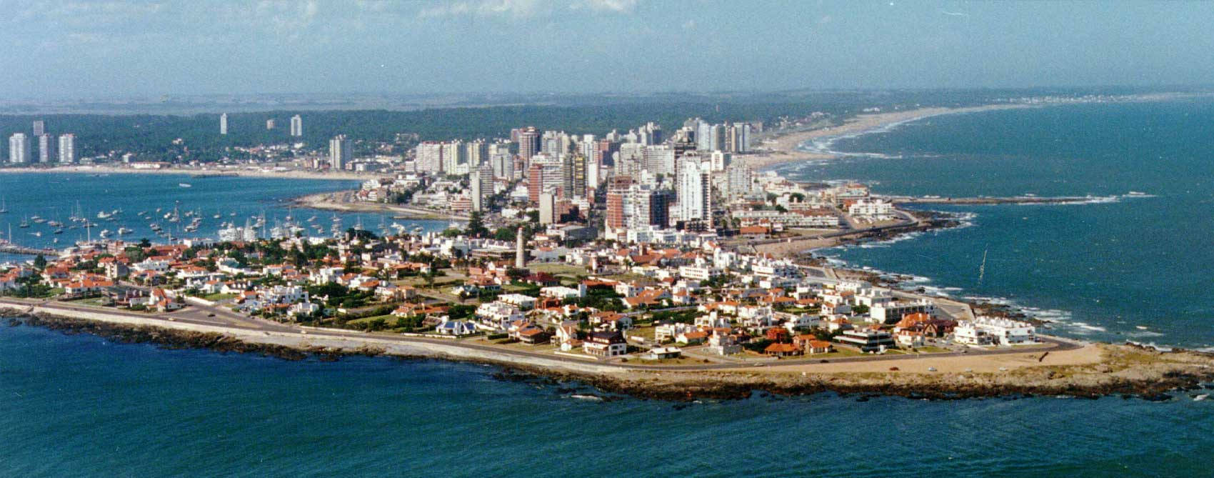 Uruguay 桌布 壁紙 — 沿海城市的鳥瞰圖，擁有現代高層建築和一個被碧綠海水環繞的歷史半島。