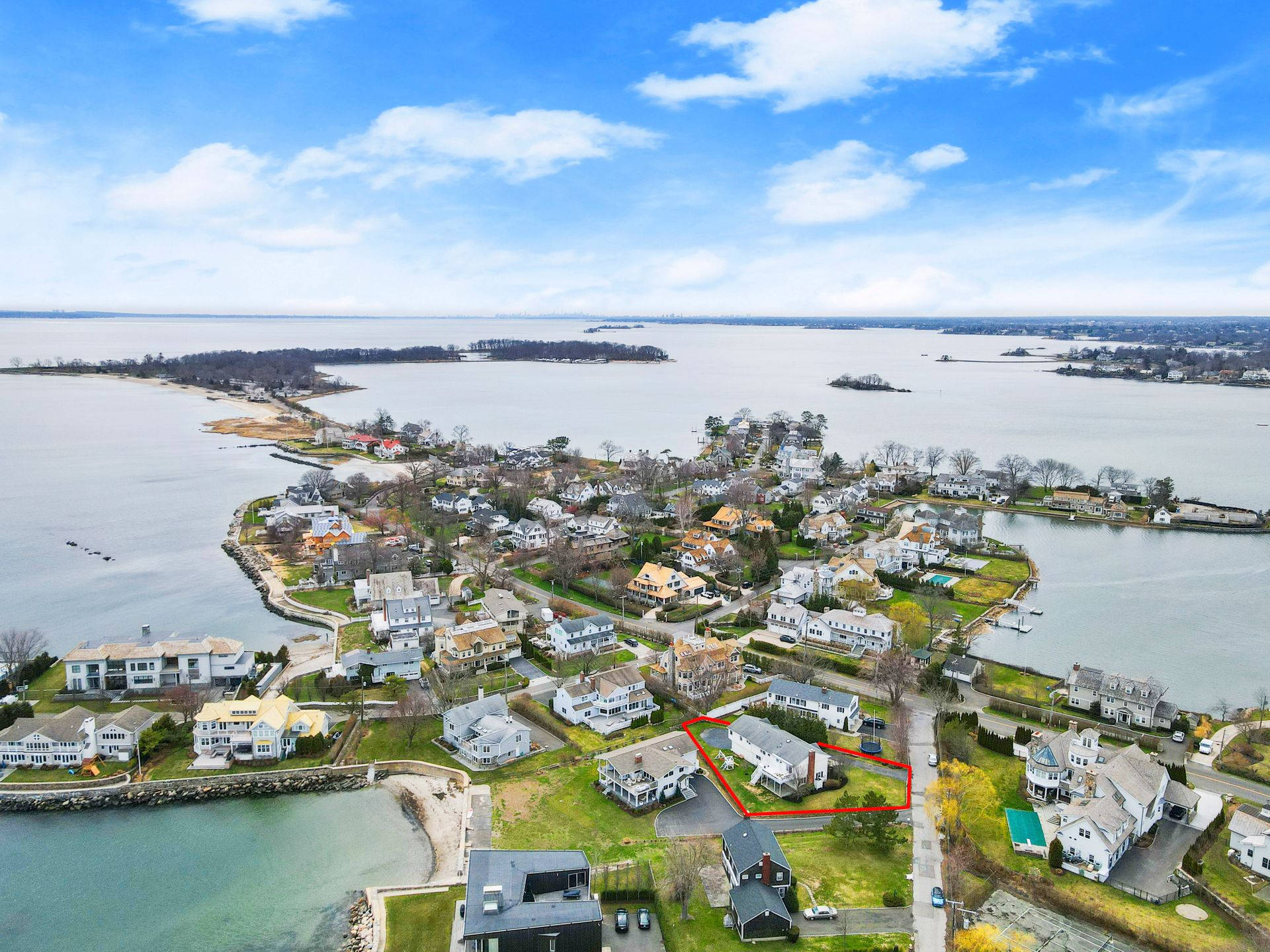 城市 桌布 壁紙 — 沿海社區的鳥瞰圖，擁有海濱住宅和島嶼，天空湛藍，雲朵稀疏。