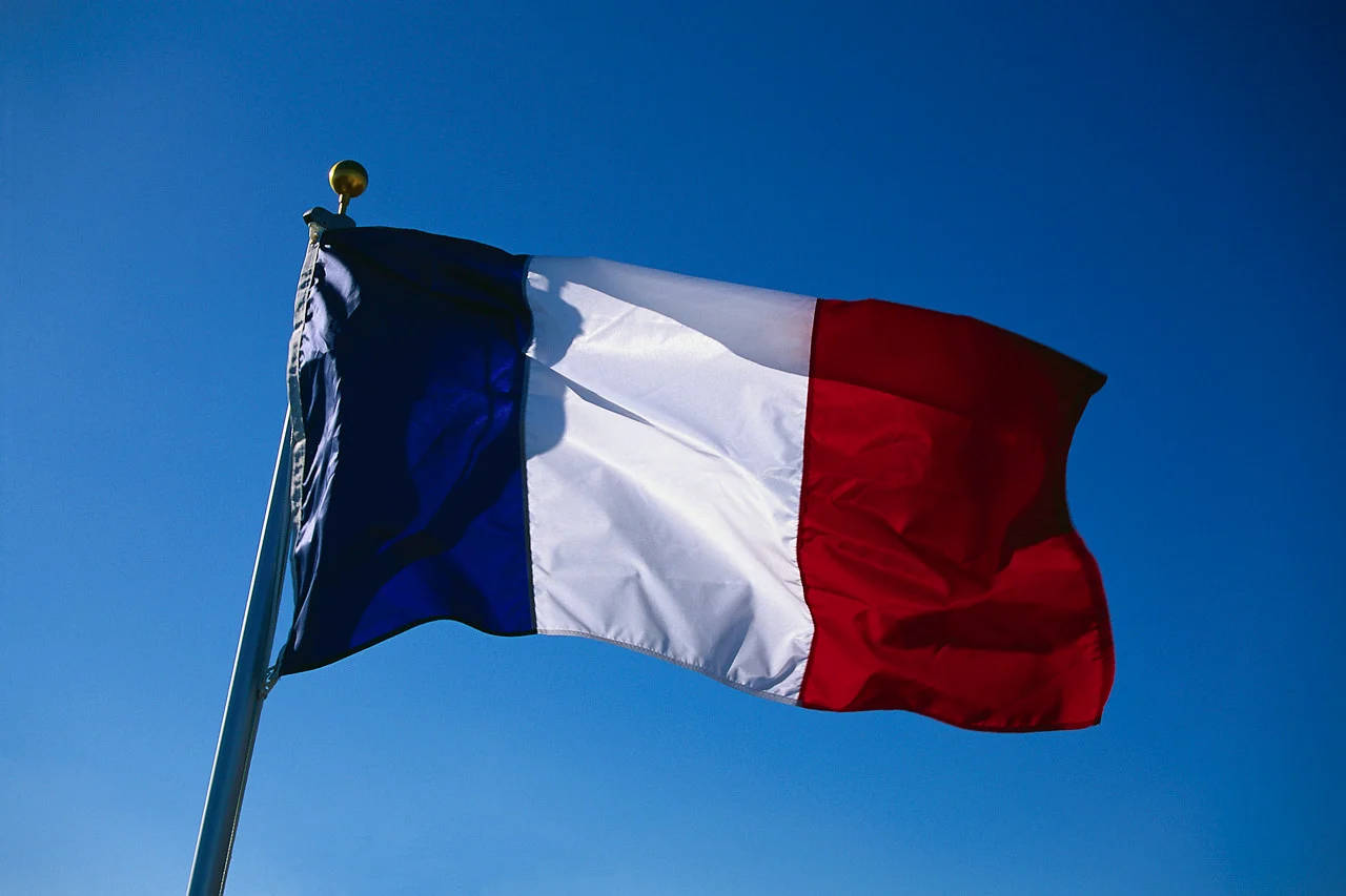 France Flag 桌布 壁紙 — 法國三色旗在晴朗的藍天下驕傲地飄揚。
