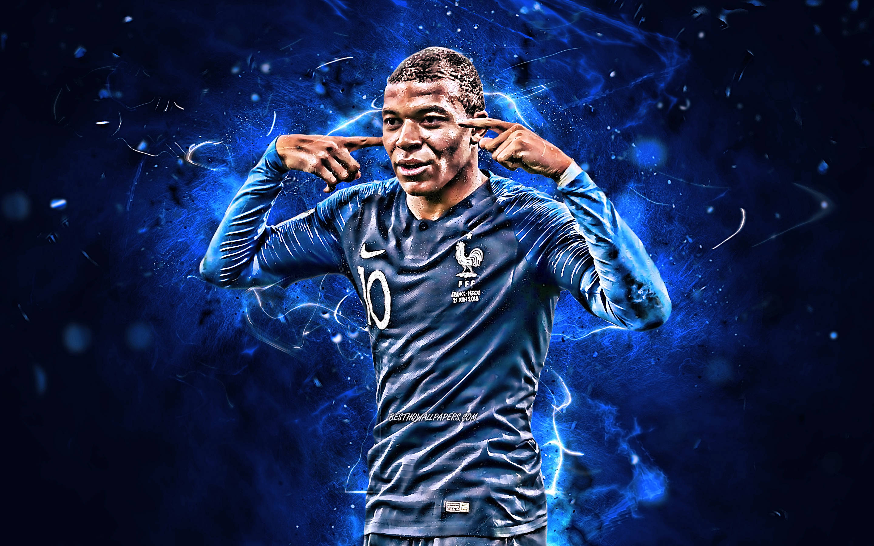 Mbappe 桌布 壁紙 — 法國足球員基利安·姆巴佩身穿法國球衣，手指放在耳邊，背景是電光藍色能量爆發。