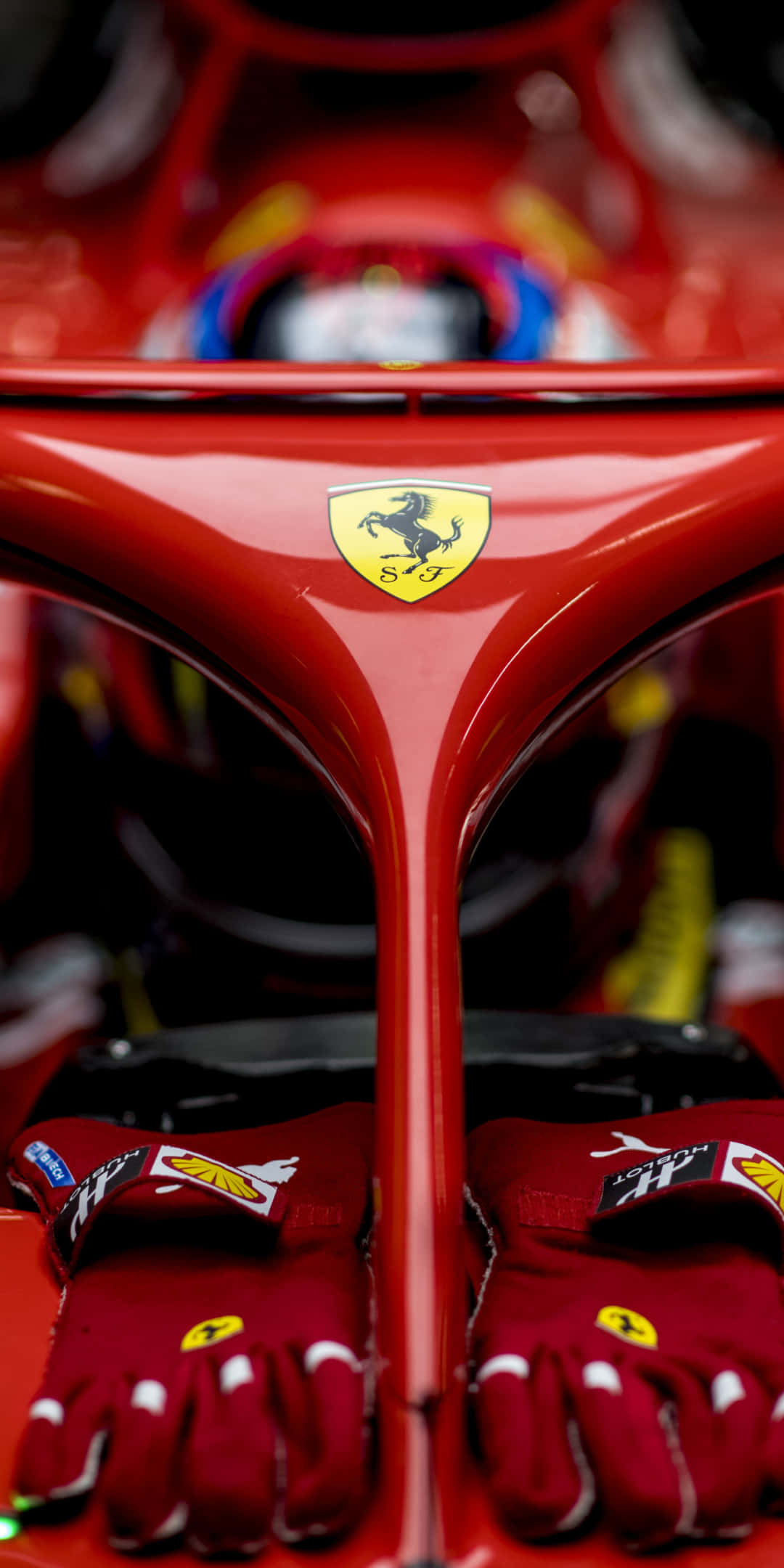 F1 桌布 壁紙 — 法拉利F1賽車紅色鼻錐、車手手套及標誌性躍馬標誌的特寫。