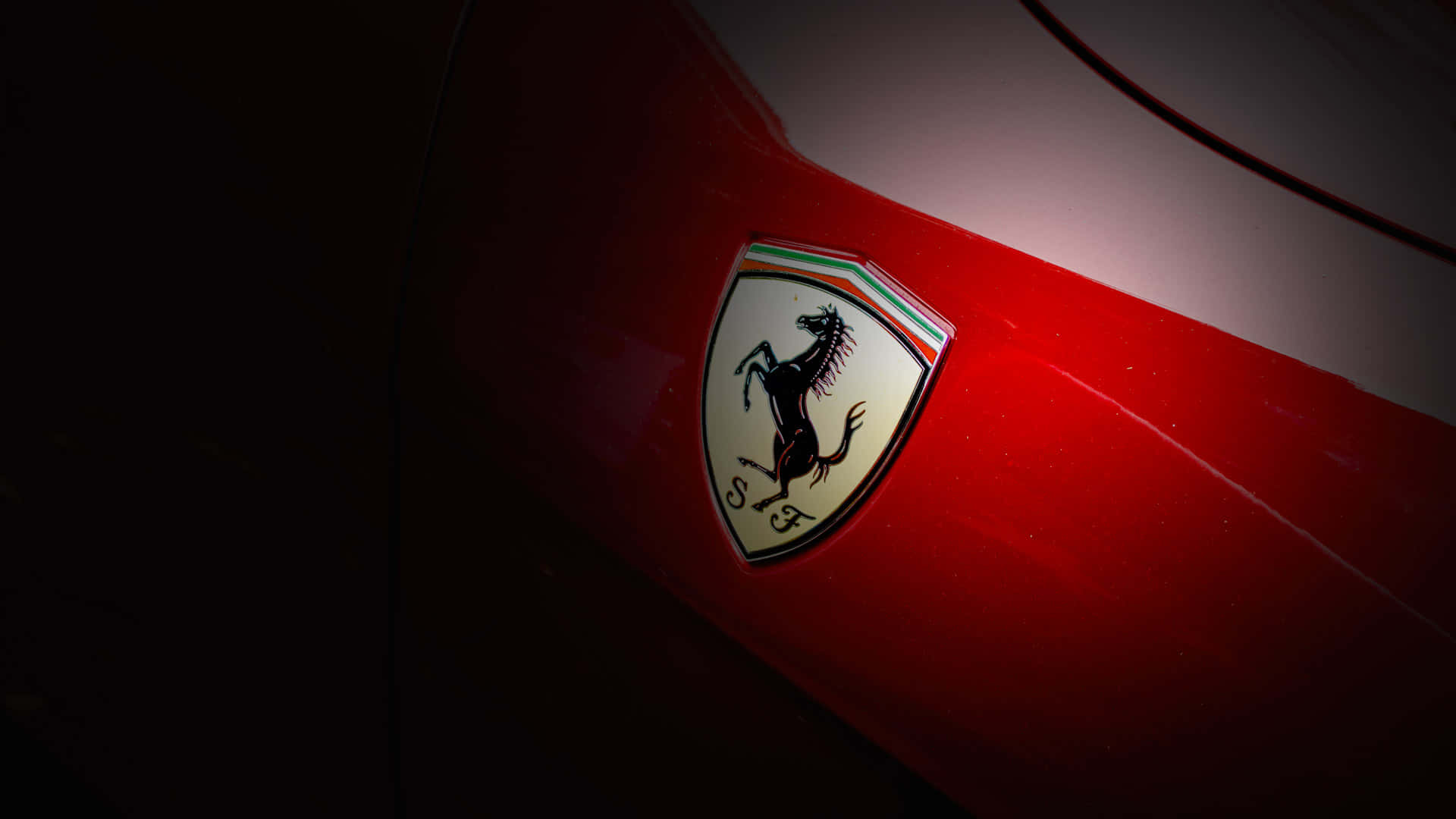 Luxury Brands 桌布 壁紙 — 法拉利標誌在戲劇性聚光燈下於光滑紅色引擎蓋上發光的特寫。