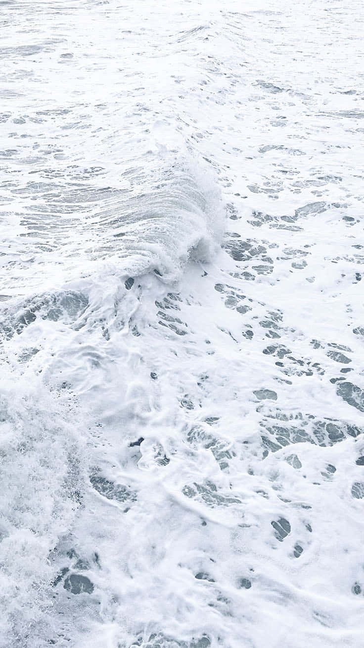 Cute Beach iPhone 桌布 壁紙 — 泡沫海浪翻滾而來的特寫，帶有紋理的白泡沫和灰藍色海水。