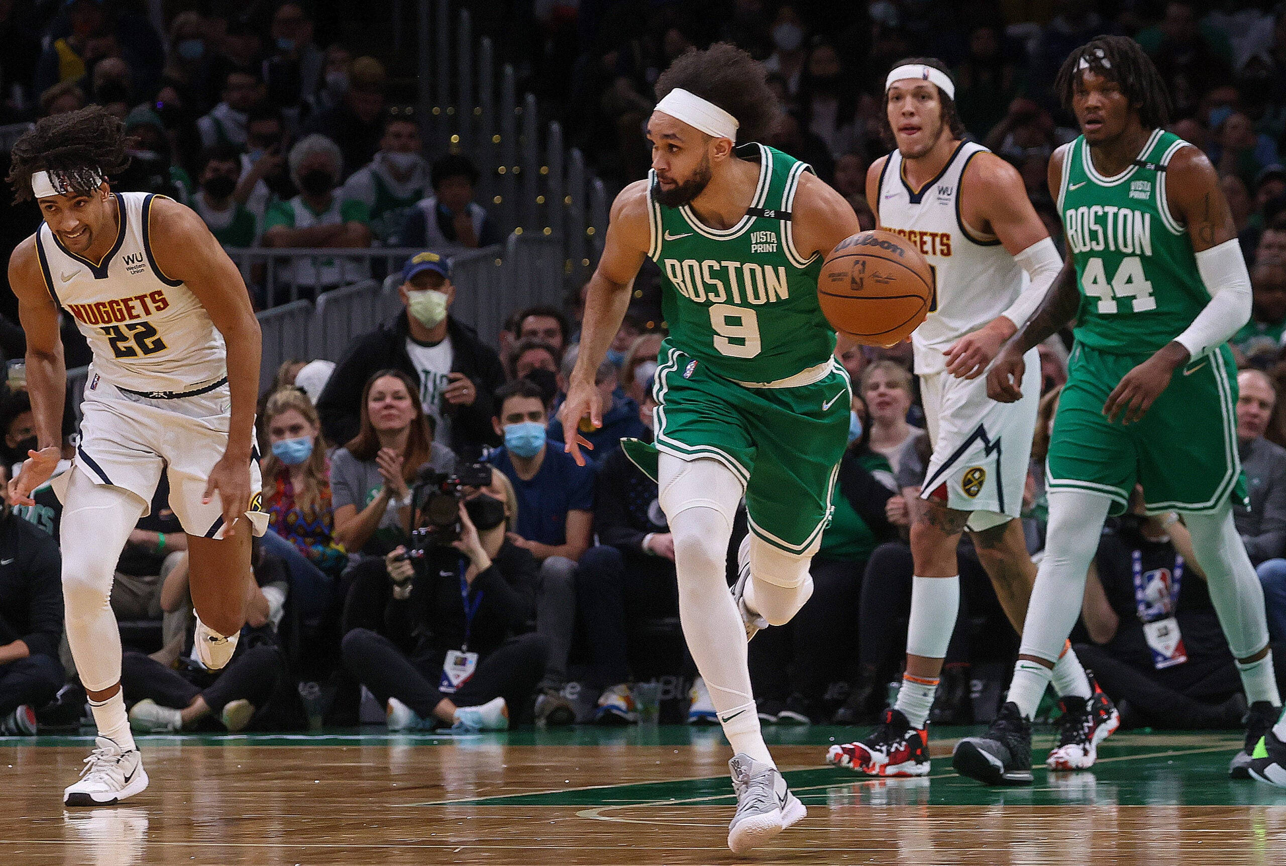 NBA 桌布 壁紙 — 波士頓塞爾提克球員在激烈的NBA比賽中運球，同時被丹佛金塊防守球員防守。