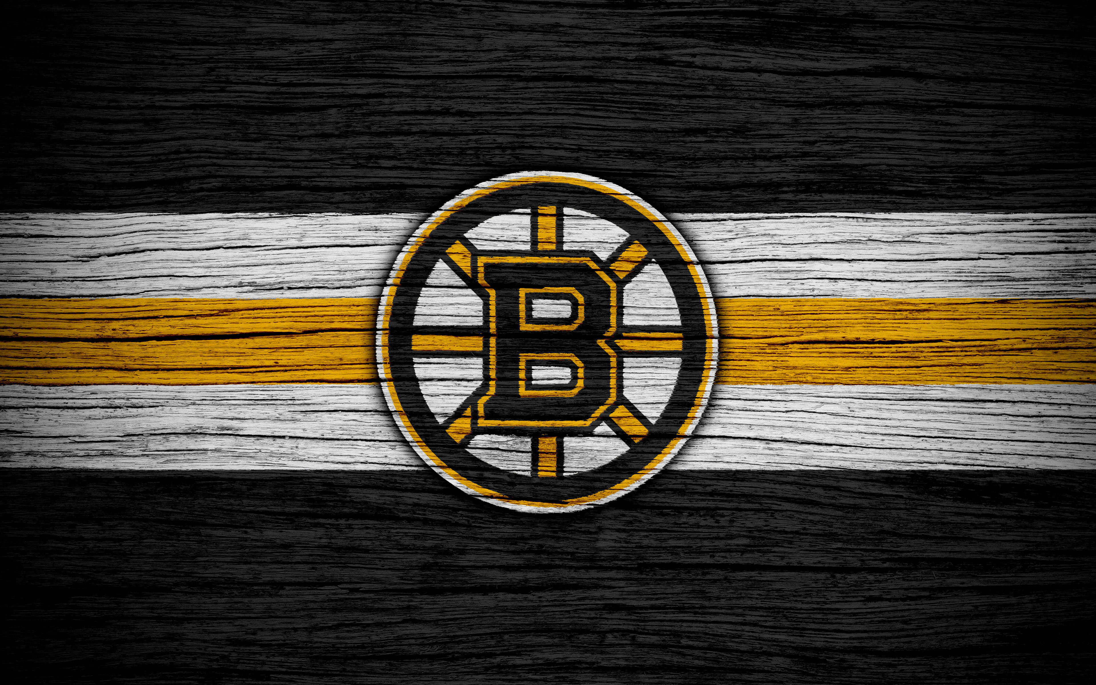 bruins 桌布 壁紙 — 波士頓棕熊隊標誌居中放置於風化的黑色、白色和金色木板上，帶有鮮明的木紋紋理。