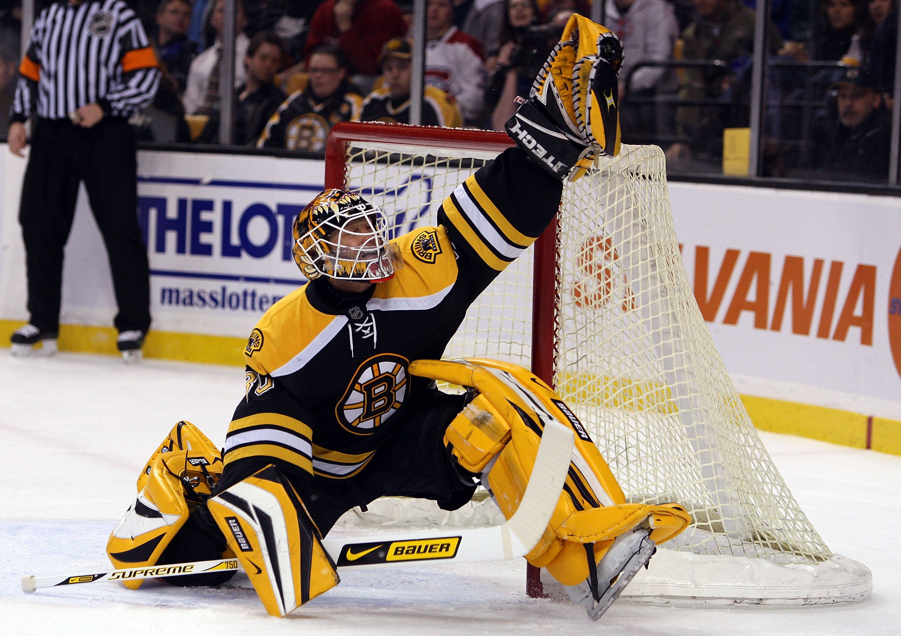 bruins 桌布 壁紙 — 波士頓棕熊隊的冰球守門員身穿黃黑裝備，在比賽中於冰上做出戲劇性的撲救。