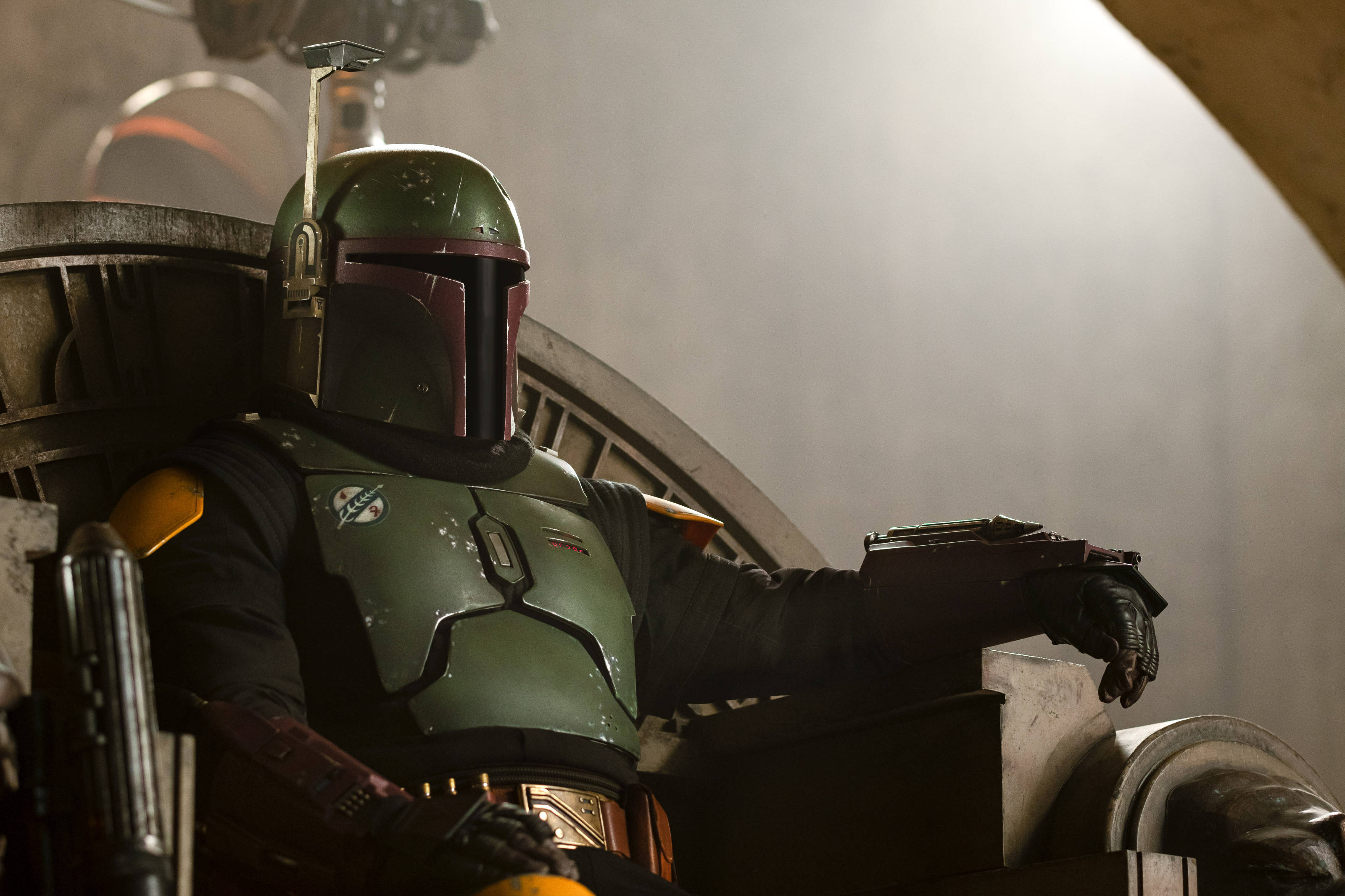 Boba 桌布 壁紙 — 波巴·費特穿著標誌性的綠色盔甲，在昏暗的工業環境中，戲劇性的燈光下，威嚴地坐在王座上。