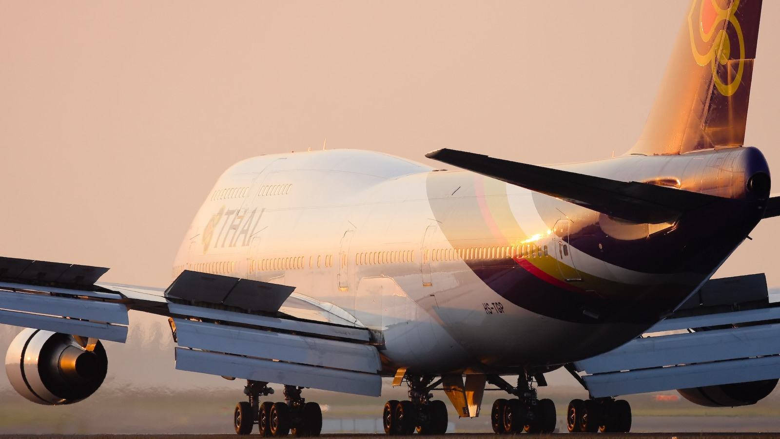 Airport 桌布 壁紙 — 泰國航空的波音747在金色夕陽下於跑道滑行，閃閃發光。