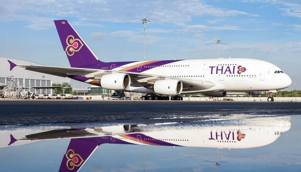 Airport 桌布 壁紙 — 泰國航空的空中巴士A380在明亮的藍天和零星雲朵下，完美地倒映在濕滑的停機坪上。