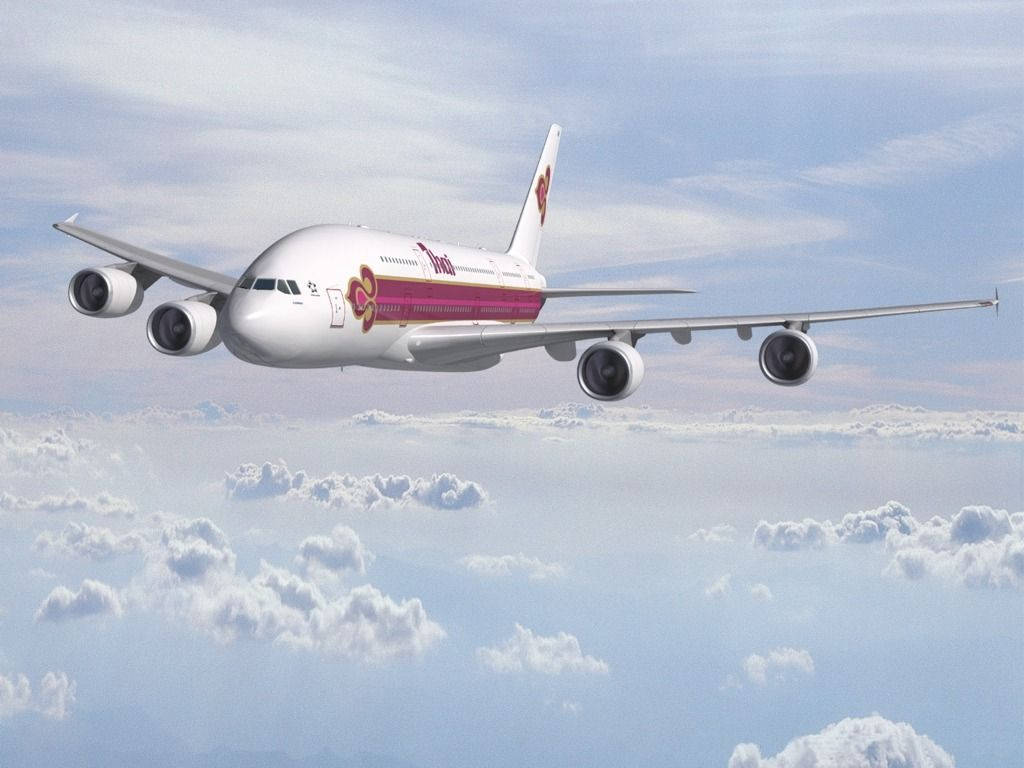 飛機 桌布 壁紙 — 泰國航空的空中巴士A380在晴朗的藍天下，優雅地翱翔於蓬鬆的白雲之上。