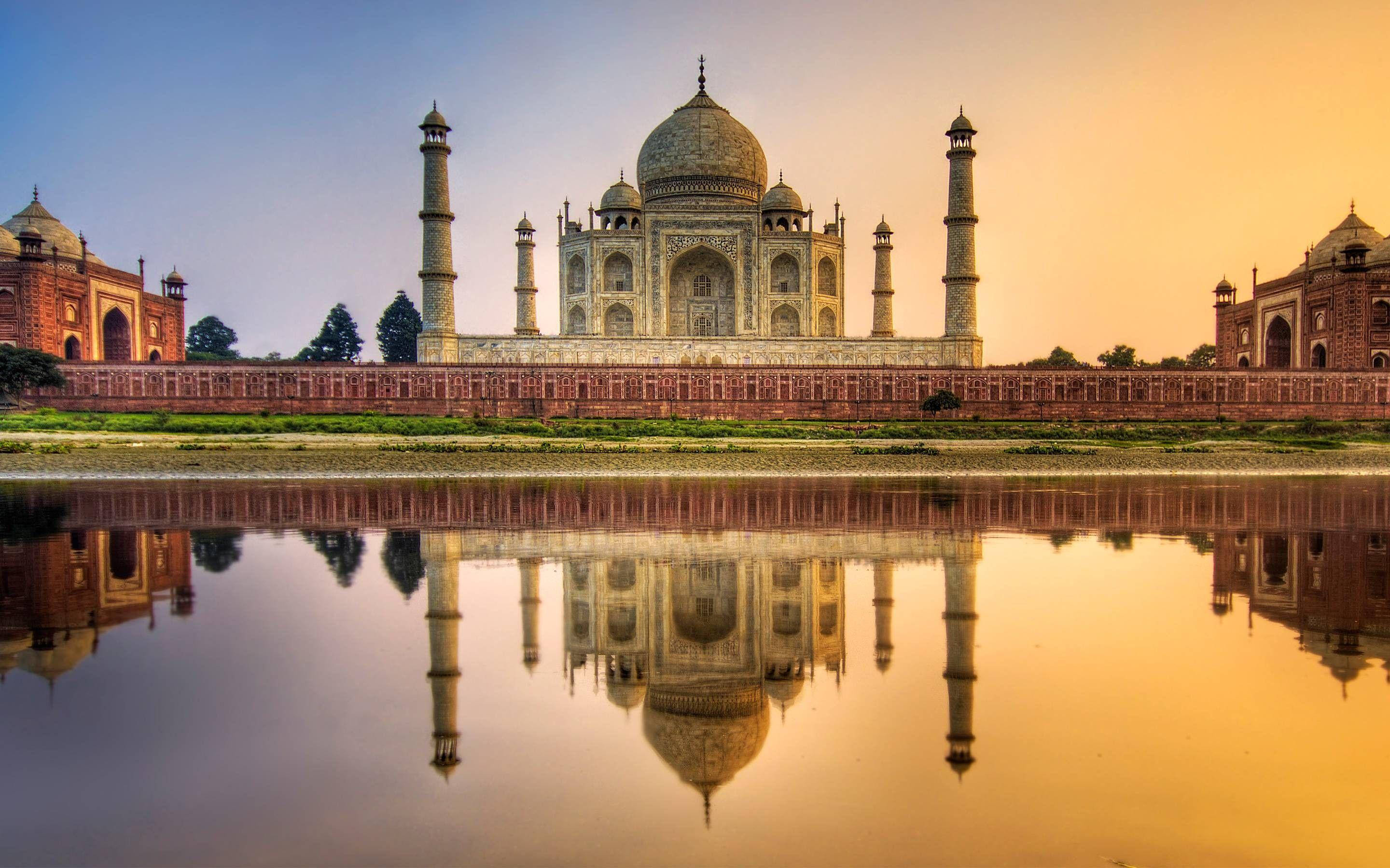 Indian 桌布 壁紙 — 泰姬陵在金色日落時完美倒映在平靜的水面上，溫暖的光線沐浴著大理石外牆。