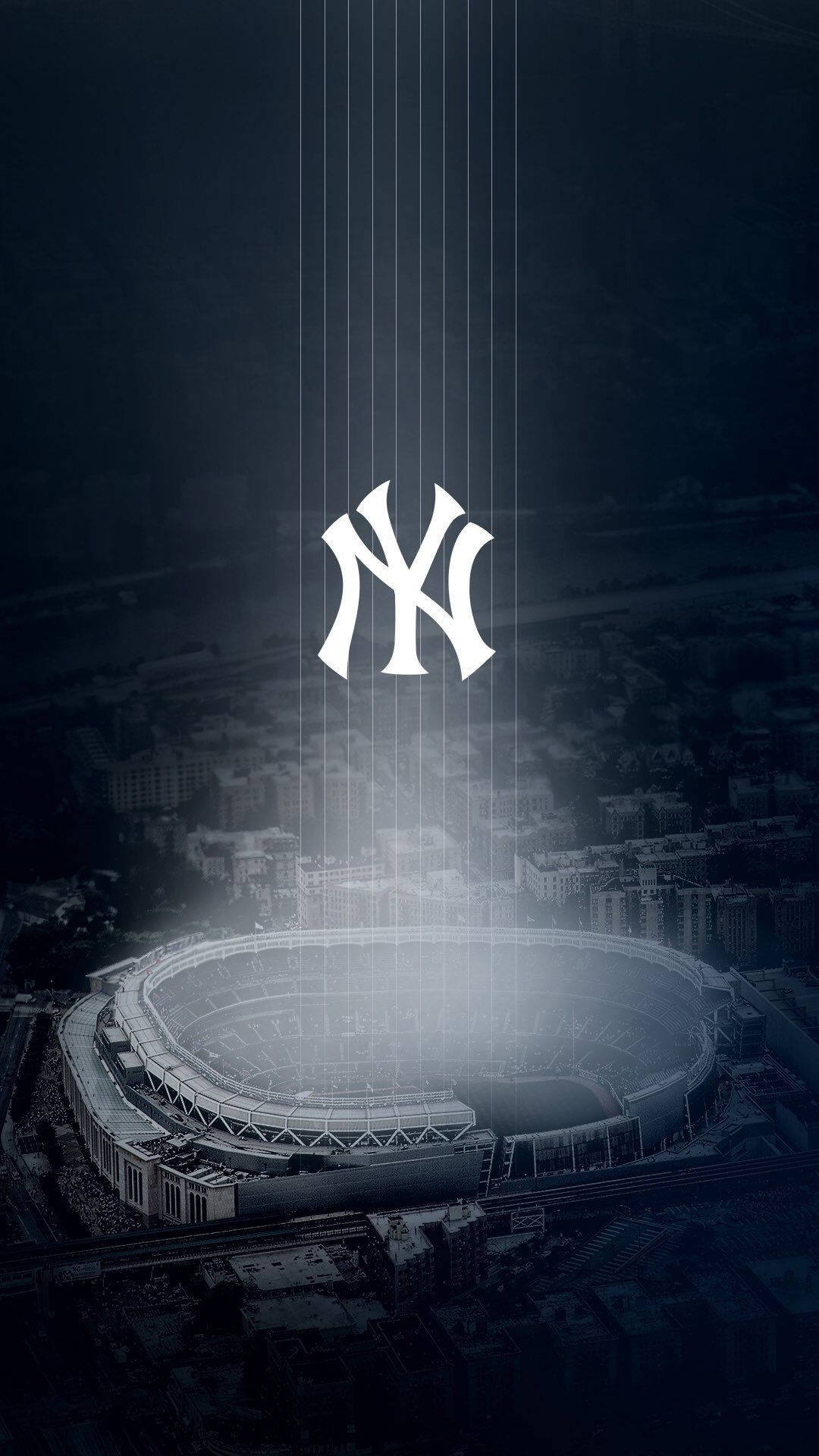Yankees Logo 桌布 壁紙 — 洋基球場的戲劇性鳥瞰圖，沐浴在發光的垂直光束中，標誌性的NY標誌懸浮在上方。
