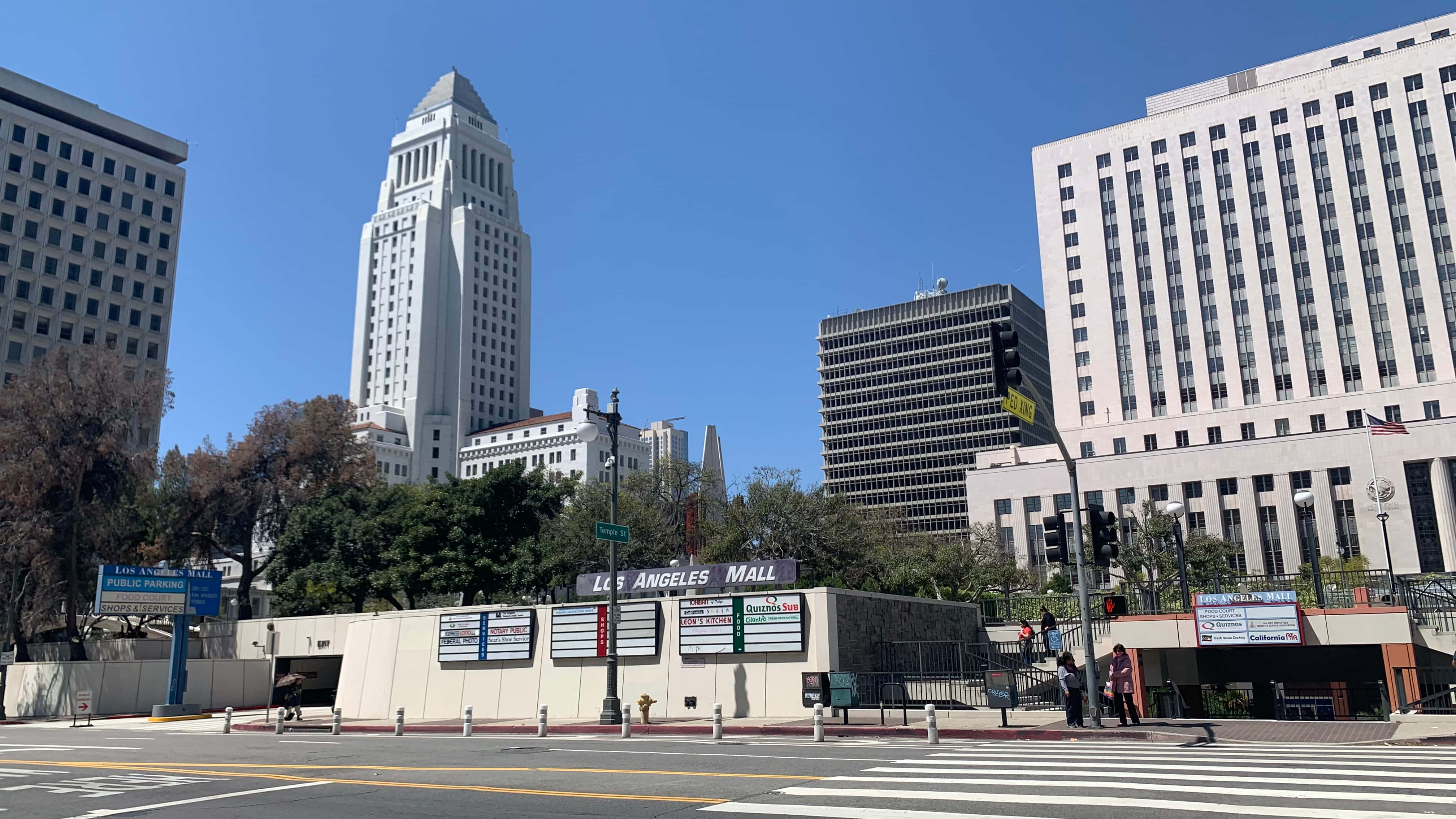 洛杉磯 桌布 壁紙 — 洛杉磯市中心一個晴朗的日子，標誌性的市政廳塔樓聳立在現代建築和繁忙的街角之上。