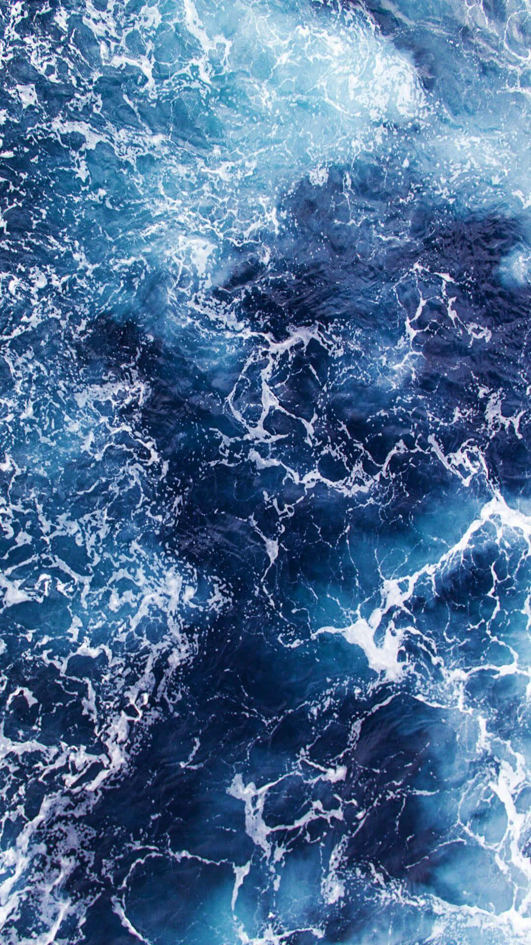 waves 桌布 壁紙 — 洶湧海浪拍打深藍海水，激起白色泡沫的航拍視角。