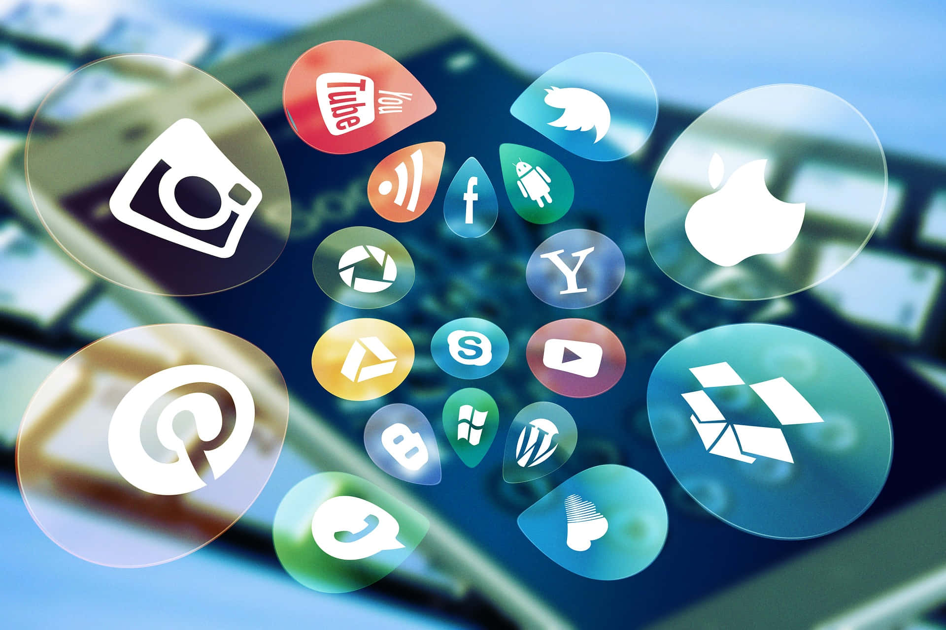 Social Media 桌布 壁紙 — 浮動社交媒體應用程式圖示懸浮在模糊鍵盤上方，呈現數位連線場景。