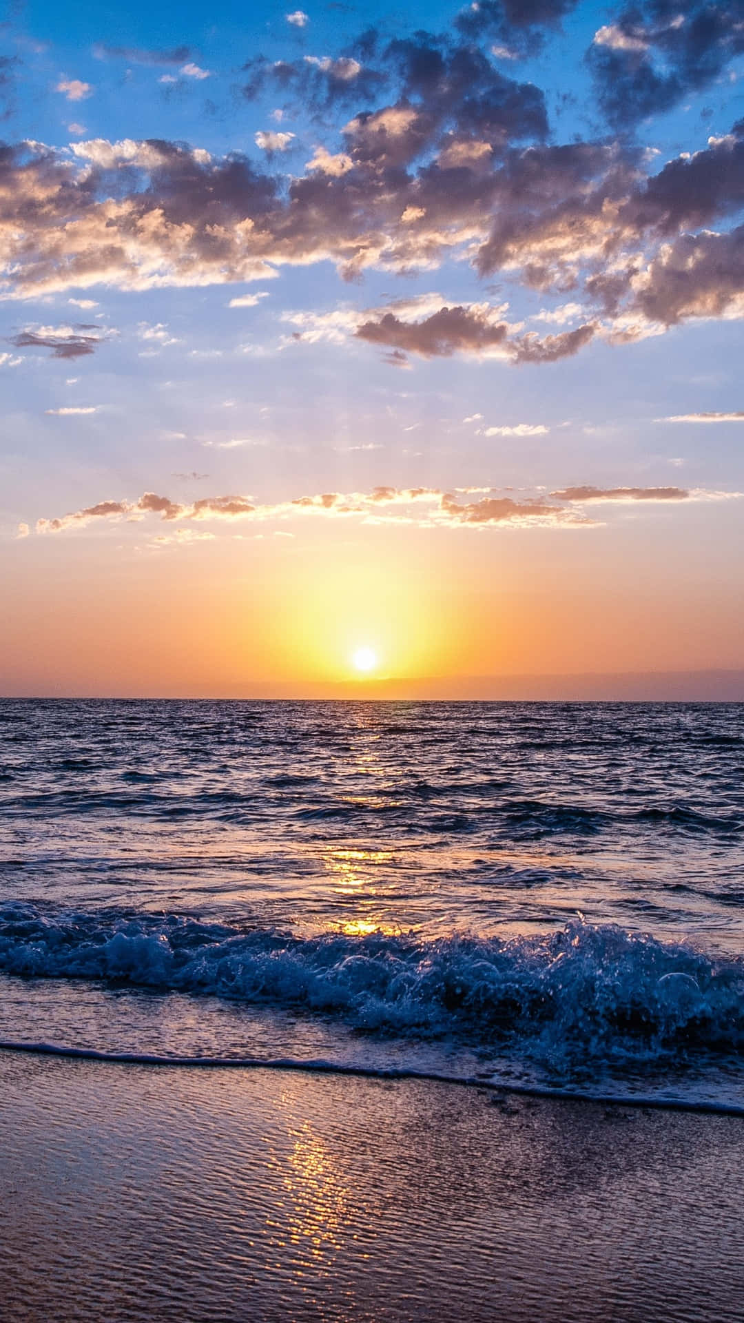 Hi Res Beach 桌布 壁紙 — 海洋上的日落，金色光線反射在波浪和雲朵上，呈現橙色、紫色和藍色調。