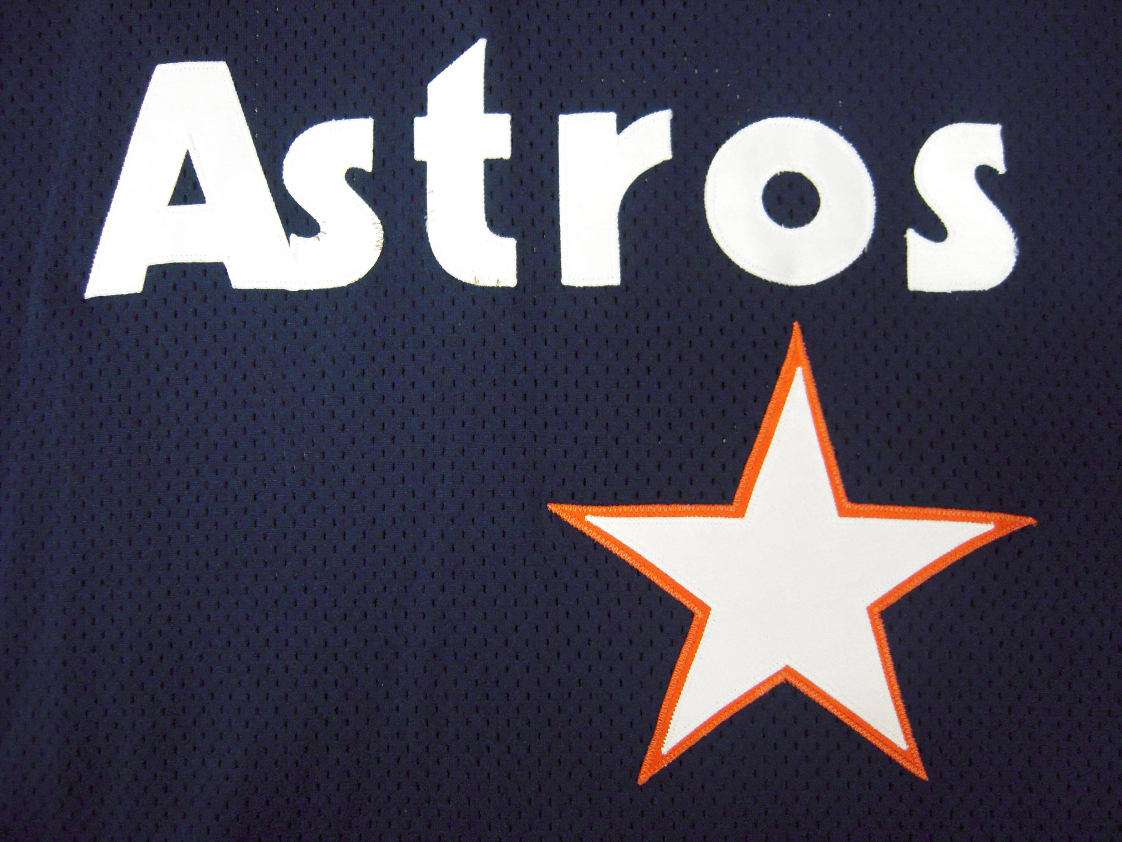 Astros 桌布 壁紙 — 海軍藍色太空人棒球球衣特寫，白色字體及白色星星，星星帶橙色輪廓。