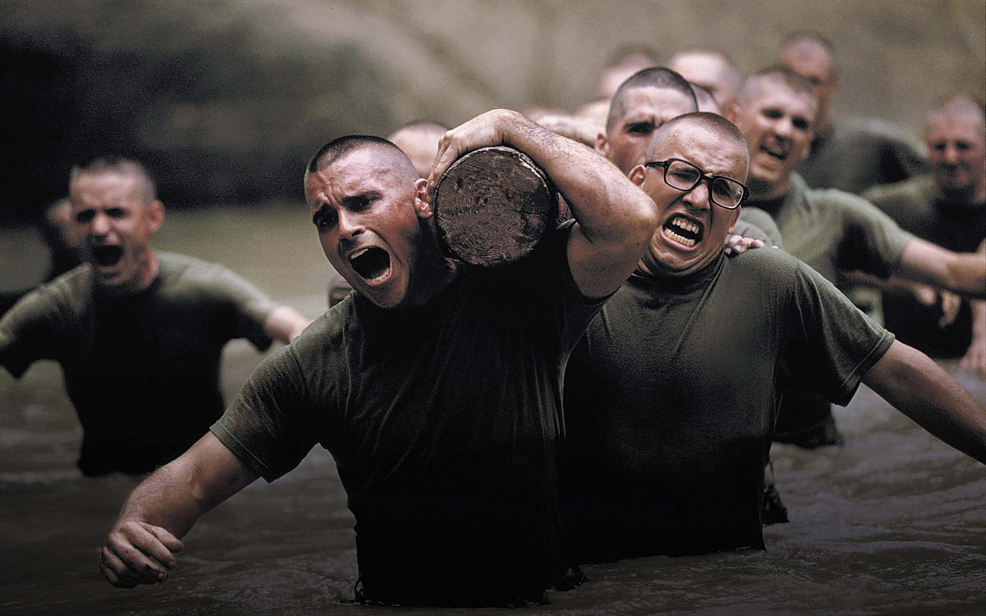 Exercise 桌布 壁紙 — 海軍陸戰隊員在泥濘的水中，在沉重的負重下奮力訓練，展現出原始的決心。