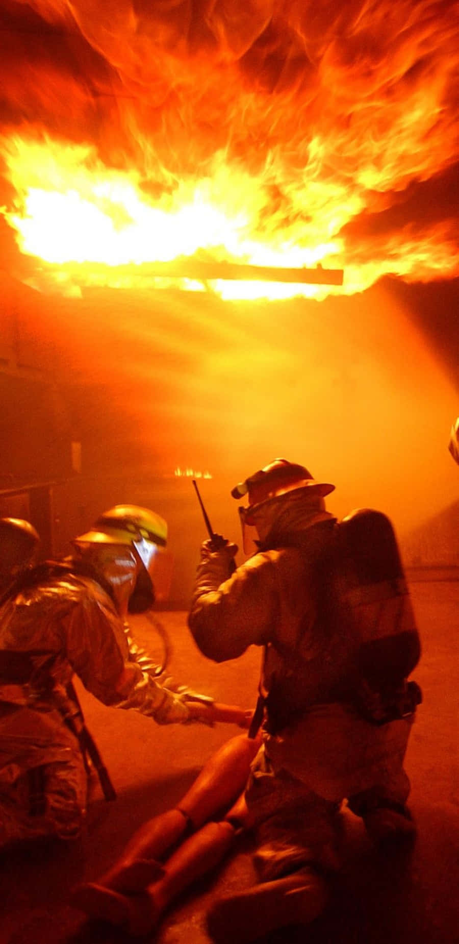 Fireman 桌布 壁紙 — 消防員全副裝備與熊熊烈火搏鬥，火焰吞噬了他們頭頂的天花板。