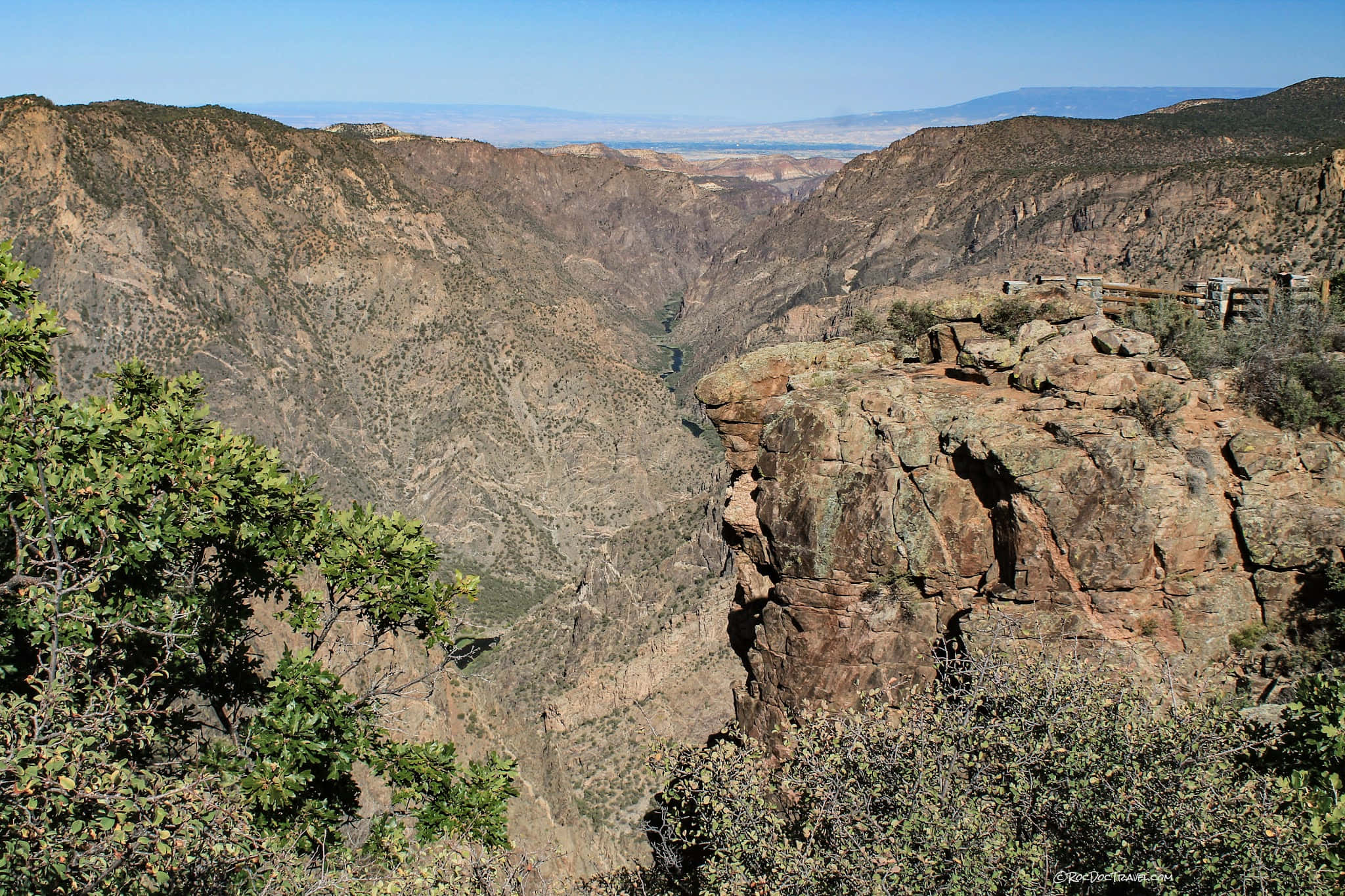Black Canyon 桌布 壁紙 — 深峽谷的壯麗景色，崎嶇的懸崖和蜿蜒的河流在清澈的藍天下。