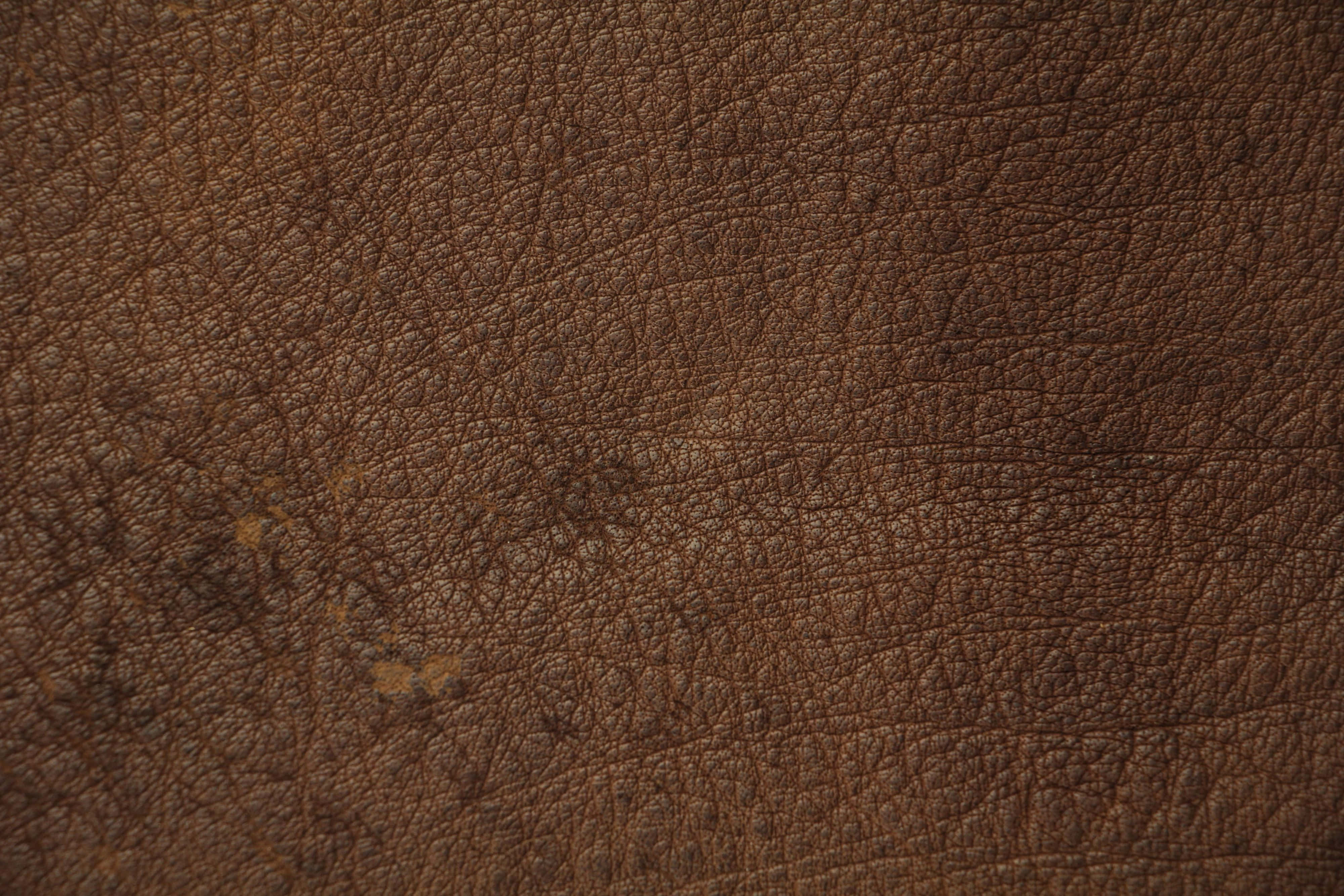 texture 桌布 壁紙 — 深棕色皮革的微距特寫，展現天然紋理和細微磨損痕跡。