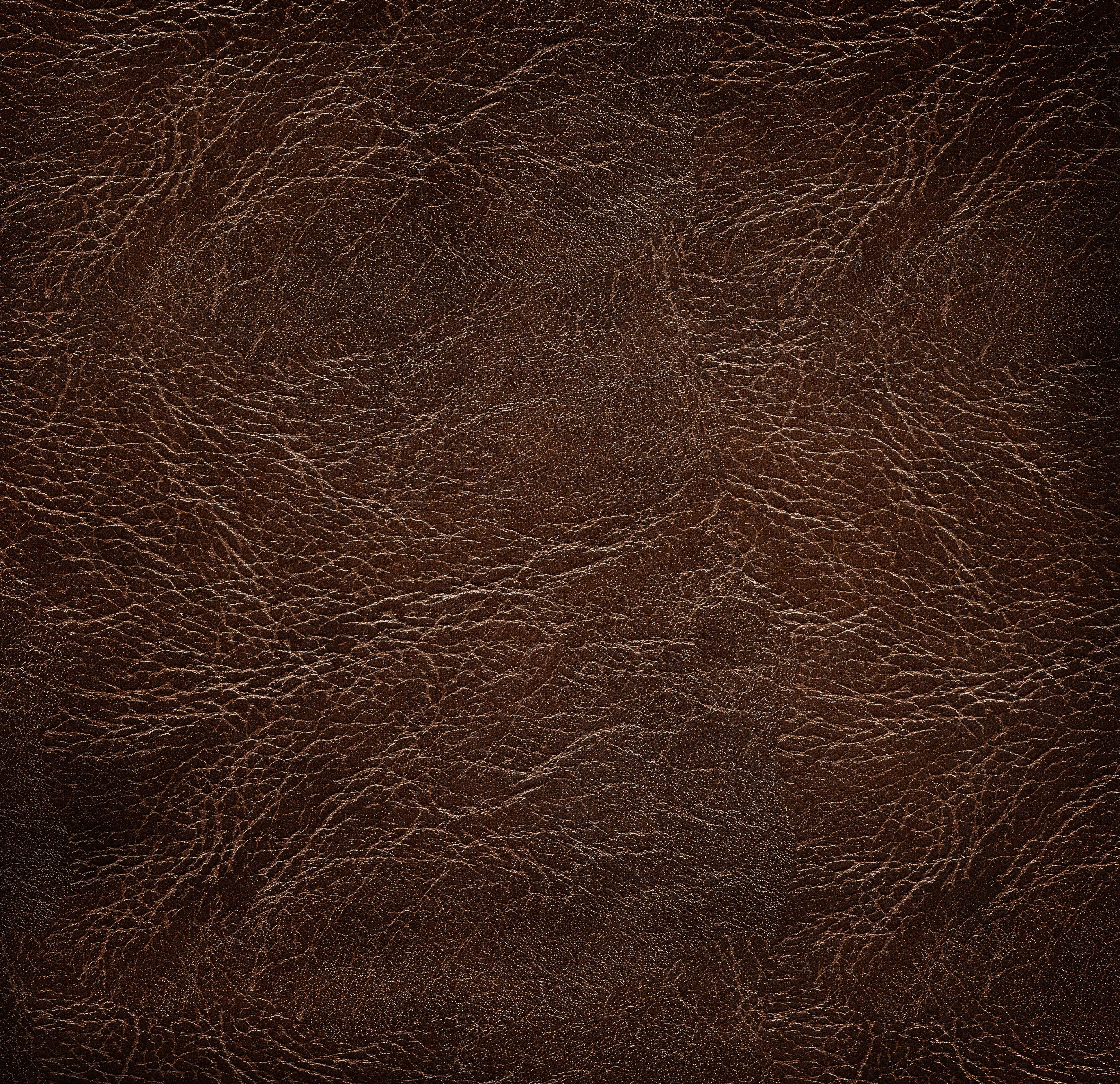texture 桌布 壁紙 — 深棕色皮革的特寫，帶有複雜的自然皺紋和細微的紋理變化。