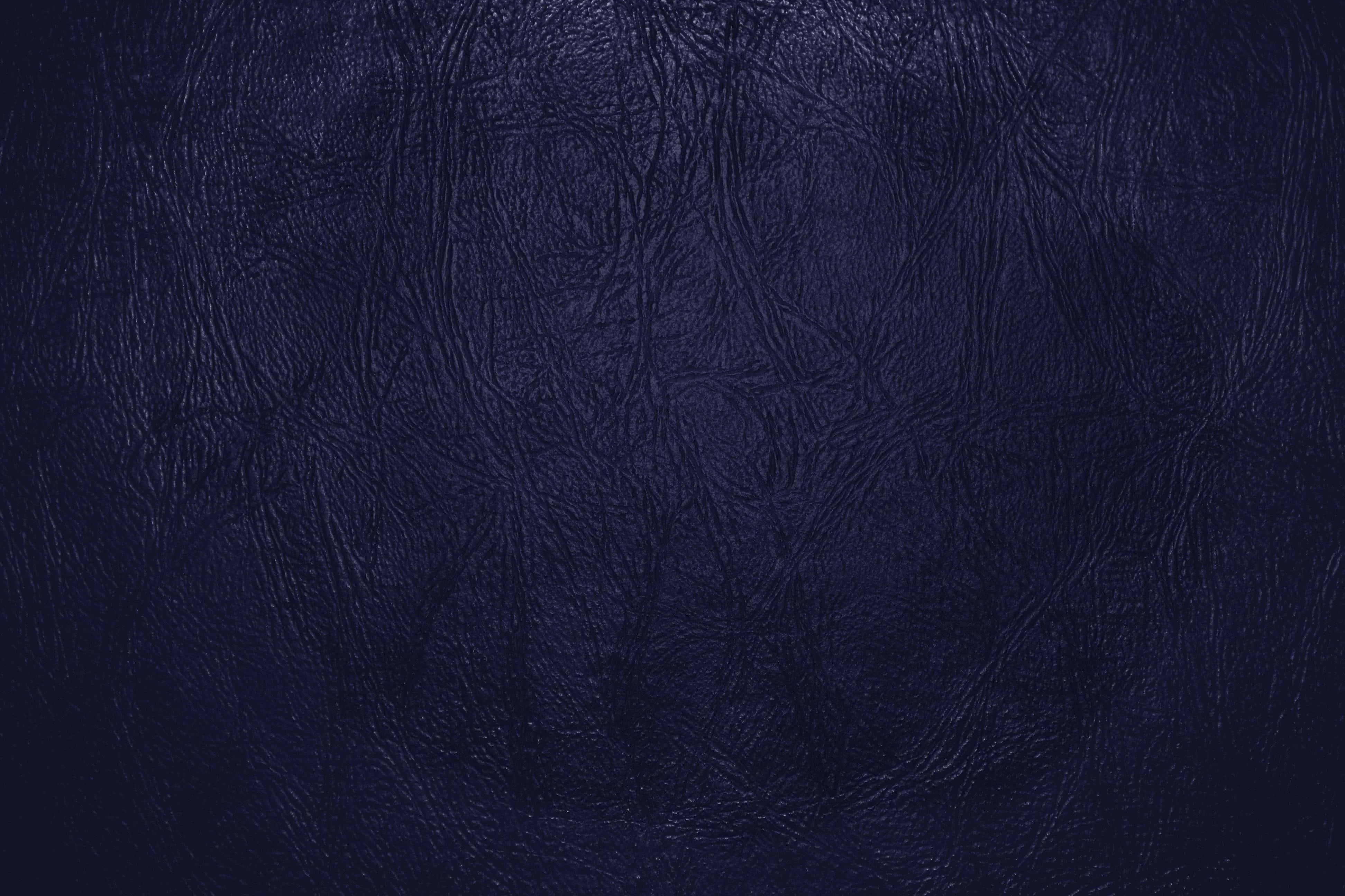 Textured 桌布 壁紙 — 深海軍藍色紋理皮革的特寫，帶有細微的摺痕和天然紋理圖案。