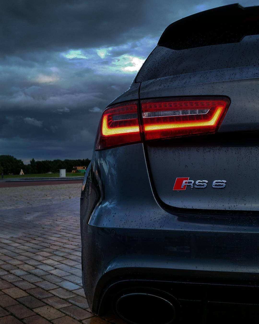 Rs 桌布 壁紙 — 深灰色奧迪RS6房車的紅色發光尾燈，在暴風雨黃昏的天空下，車身表面帶有雨滴，格外突出。