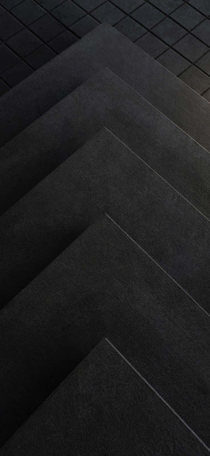 Tile 桌布 壁紙 — 深灰色紋理磁磚的特寫，以幾何人字形圖案鋪設在鋪砌表面上。