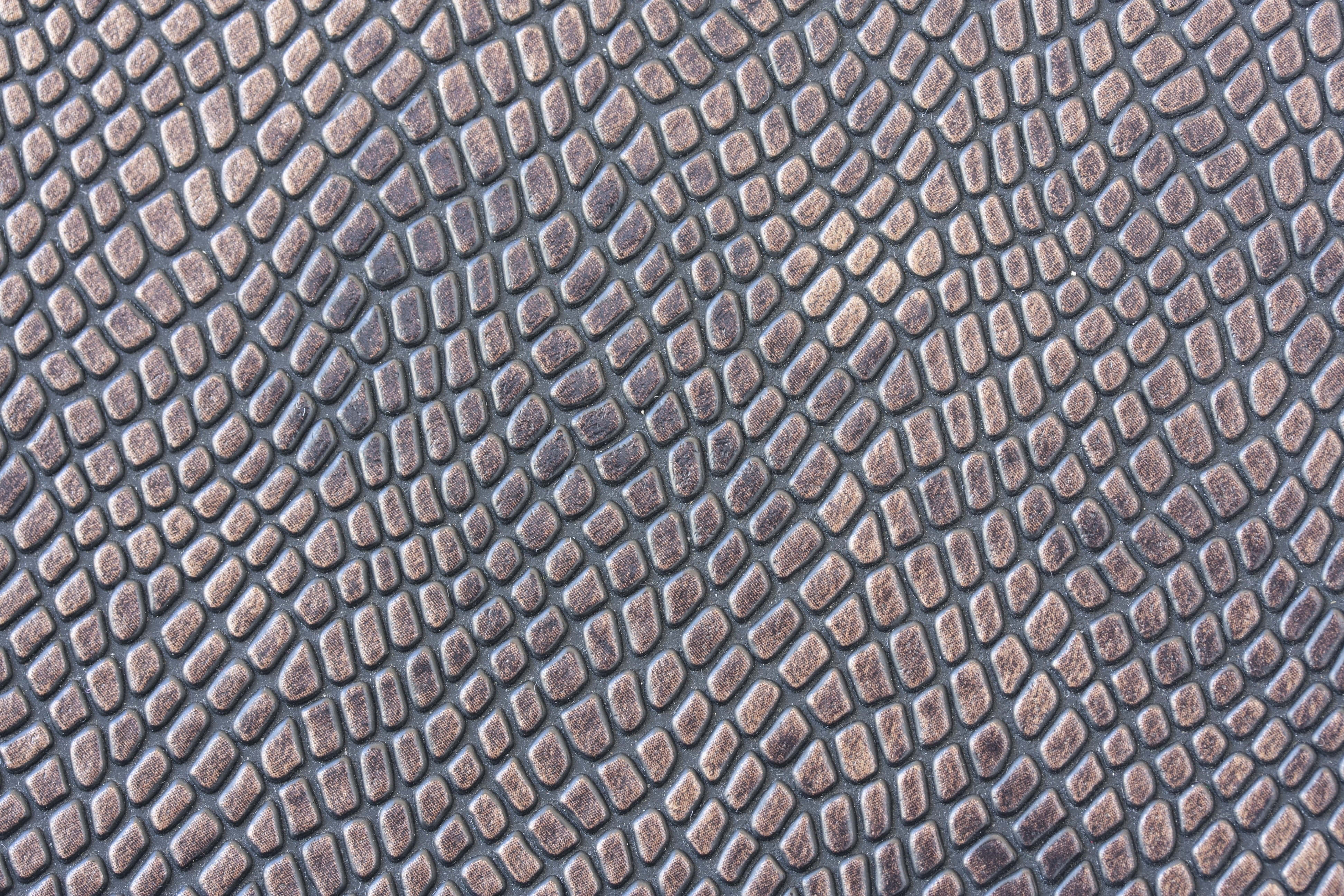 texture 桌布 壁紙 — 深灰色背景上重複的褐色菱形凸起紋理表面的特寫。