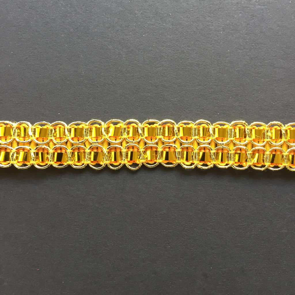 金箔 桌布 壁紙 — 深灰色表面上金色鏈甲手鐲的微距特寫，環環相扣。