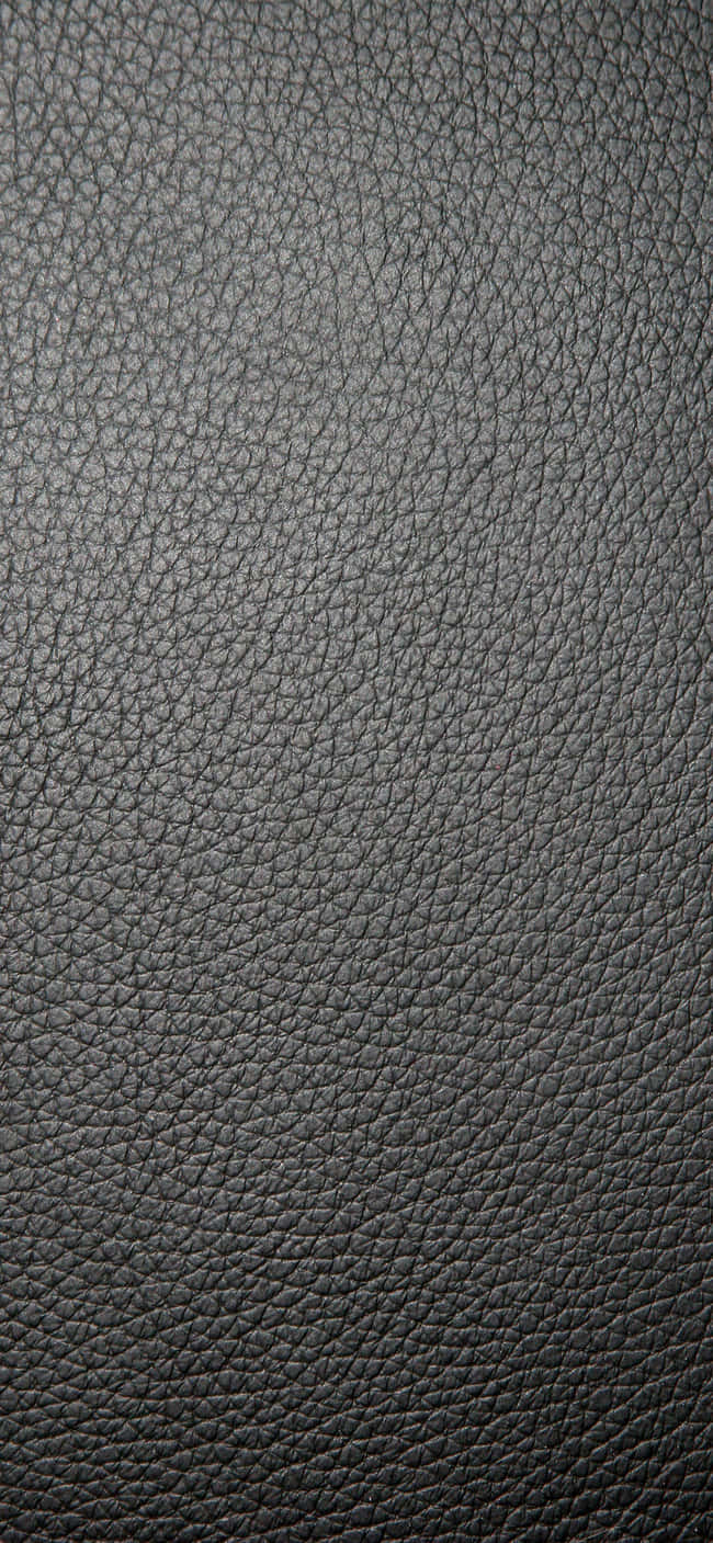 Leather 桌布 壁紙 — 深灰色鵝卵石紋皮革質感特寫，帶有細微紋理和柔和光線。